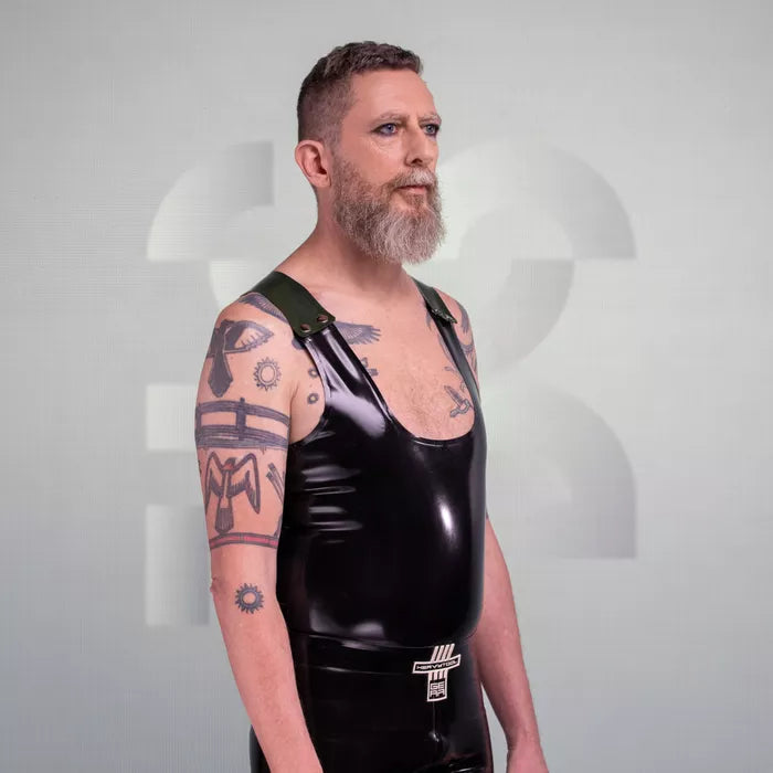 The image features a bold Latex Tank Top with Removable Straps, showcasing a striking glossy finish that complements the wearer's physique. The design features a deep scoop neck and sleek lines, enhanced by the detachable straps that offer versatility in styling. Perfect for clubbing or embracing the kink scene, this tank top makes a daring statement while ensuring maximum comfort and confidence.