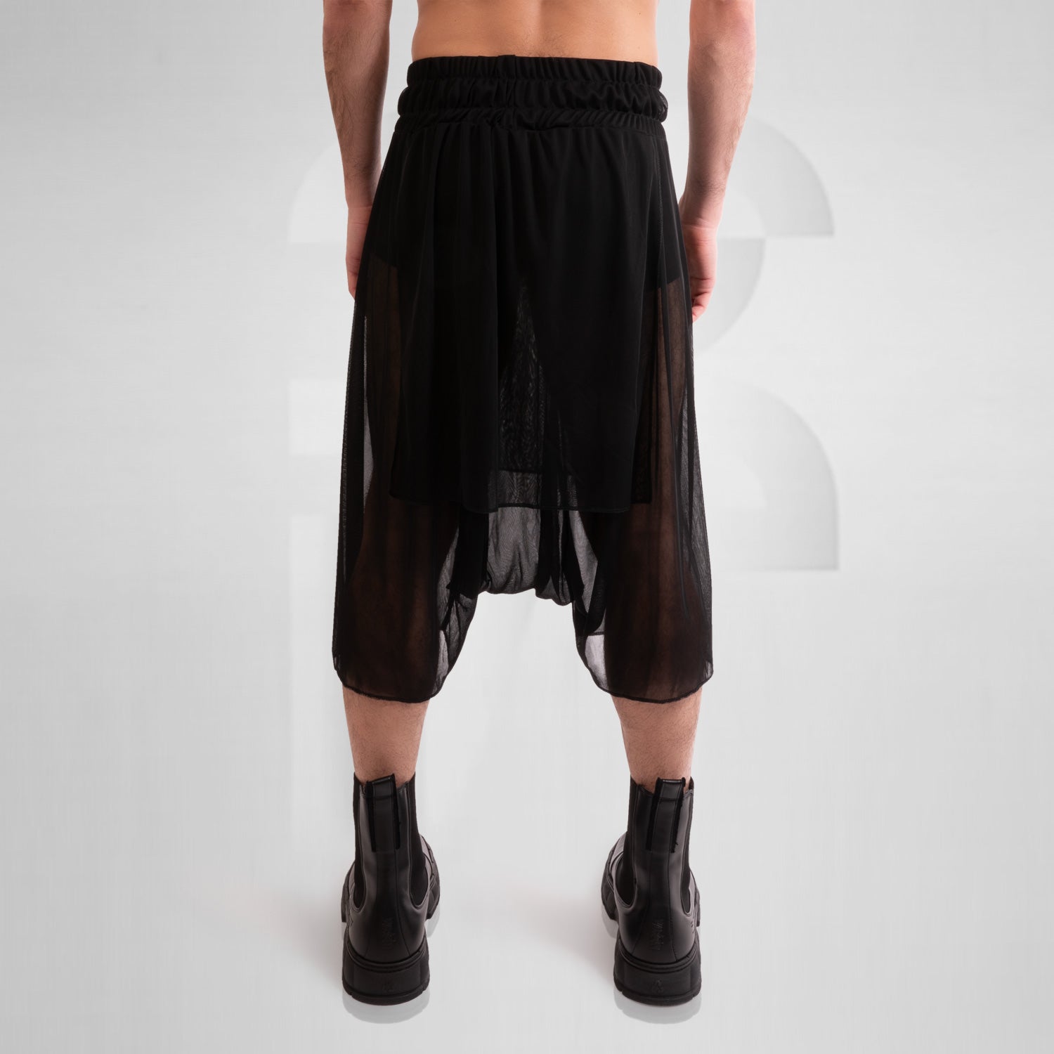 Layered Mesh Shorts from This is Fred featuring a unique layered design made of lightweight mesh, styled with black boots, ideal for avant-garde fashion and versatile wear for club nights and everyday occasions.