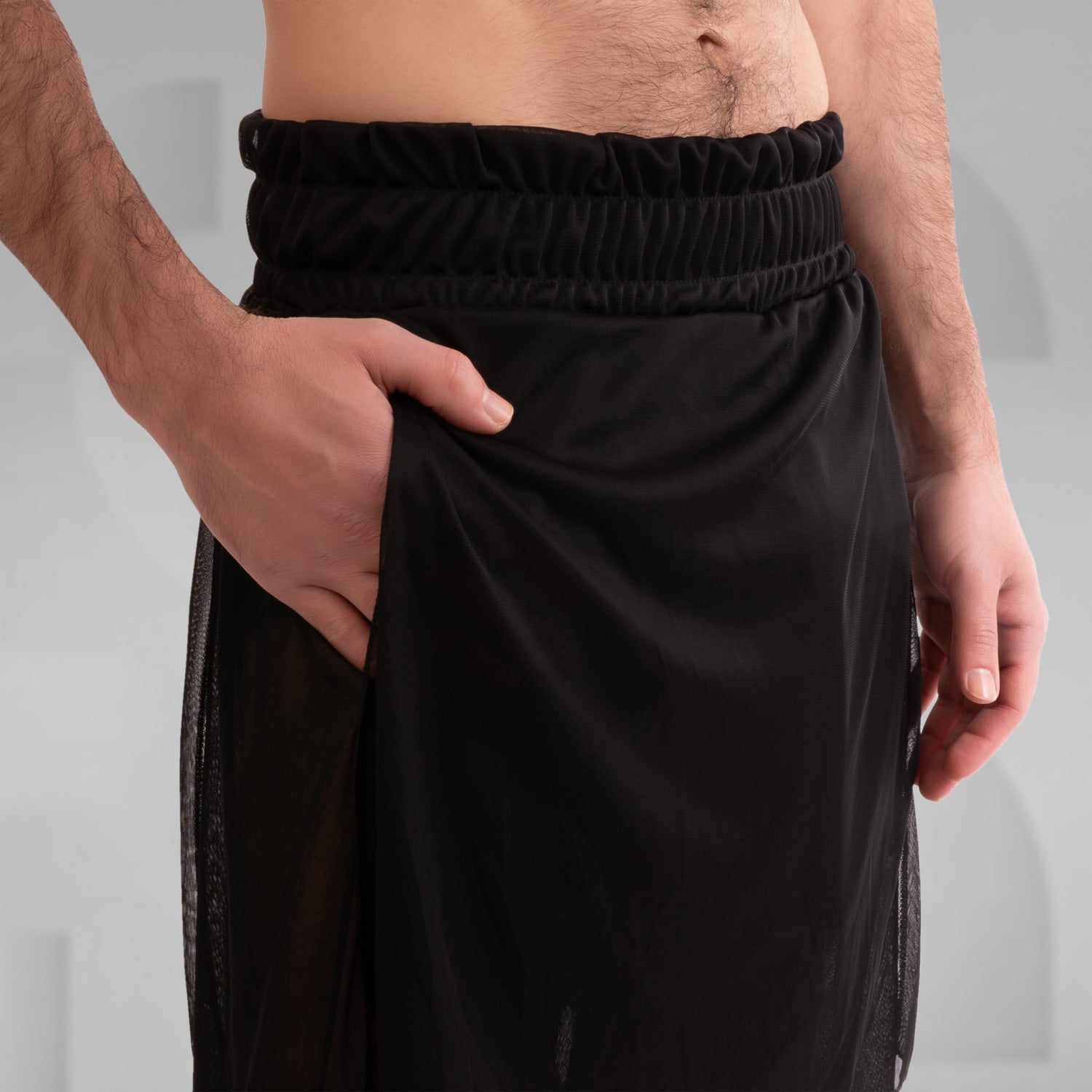 The Avantgarde Mesh Shorts from This is Fred feature a striking design with a unique silhouette and breathable mesh, ideal for festival and techno party vibes. The model showcases the shorts styled with bold black boots, emphasizing their edgy and fashionable appeal. Perfect for those looking to make a statement in their wardrobe.