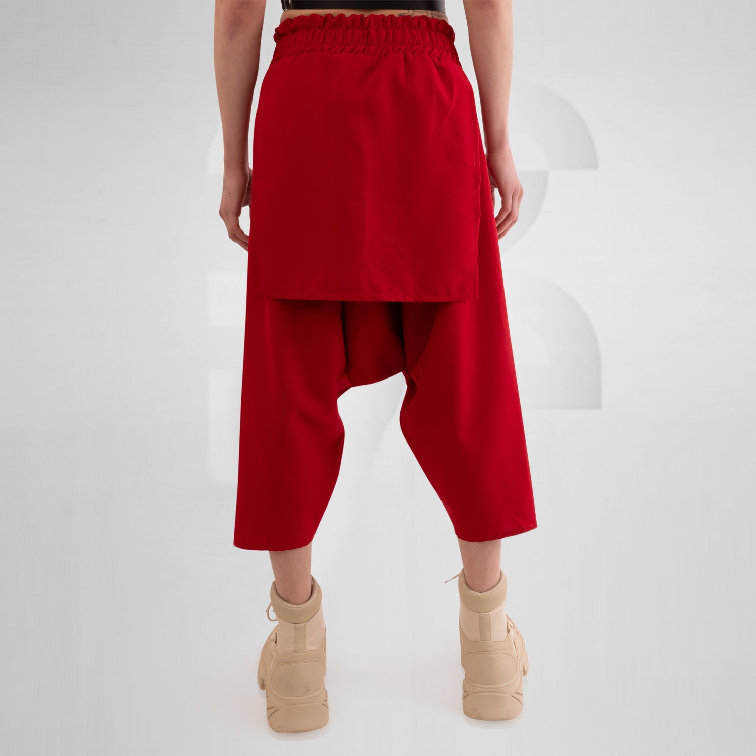 Layered Mixed Trousers by This is Fred featuring a unique layered design in a bold color, ideal for festivals and clubwear. The trousers offer freedom of movement and practical side pockets, embodying avant-garde style and functionality.