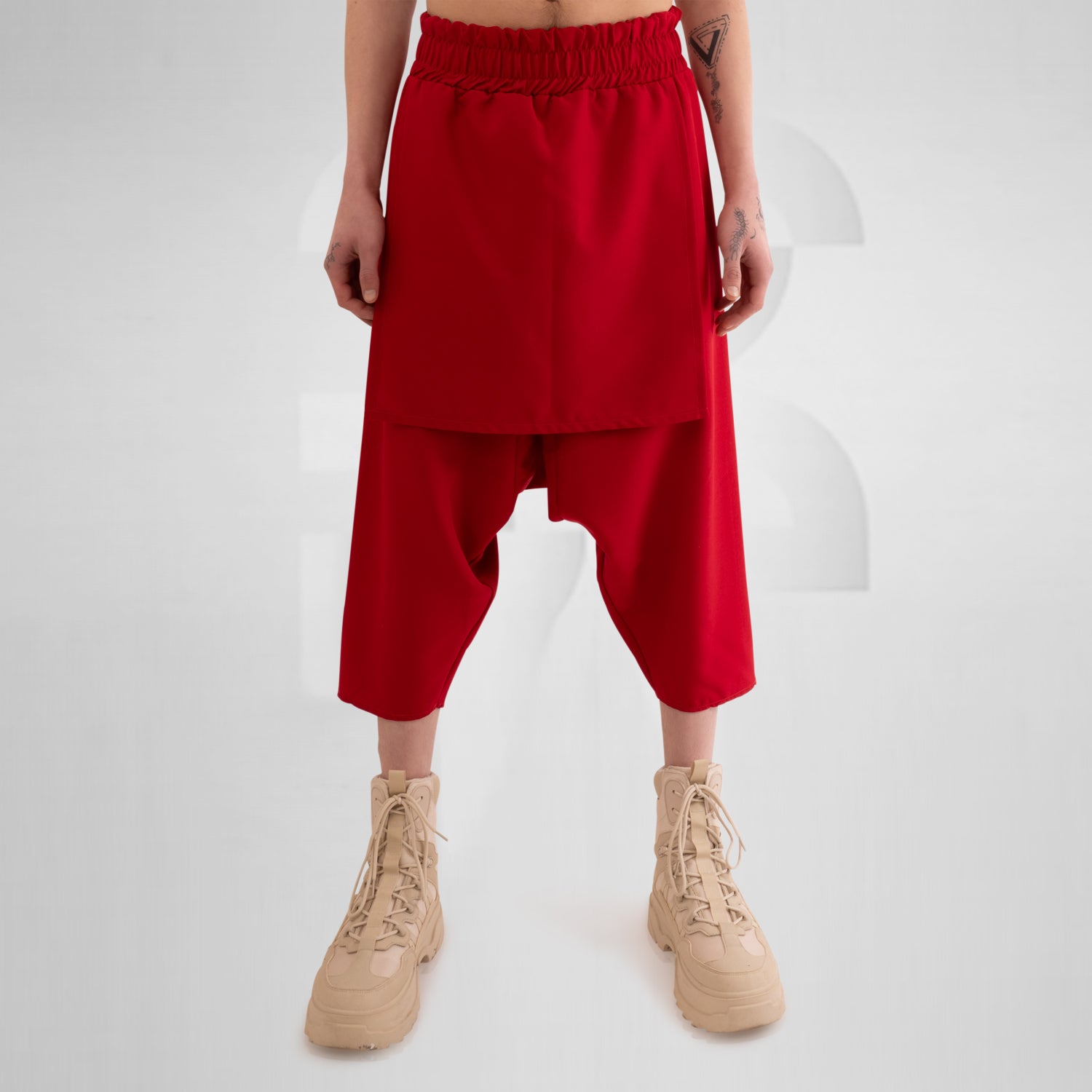 Layered Mixed Trousers by This is Fred featuring a unique layered design in a bold color, ideal for festivals and clubwear. The trousers offer freedom of movement and practical side pockets, embodying avant-garde style and functionality.