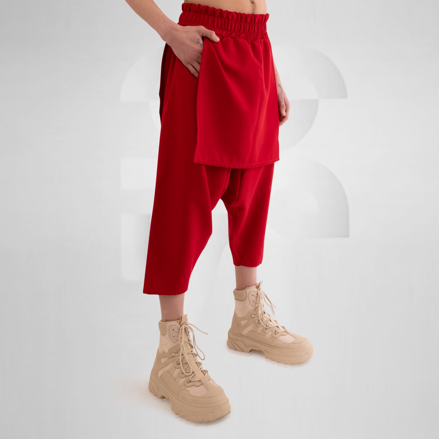 Layered Mixed Trousers by This is Fred featuring a unique layered design in a bold color, ideal for festivals and clubwear. The trousers offer freedom of movement and practical side pockets, embodying avant-garde style and functionality.