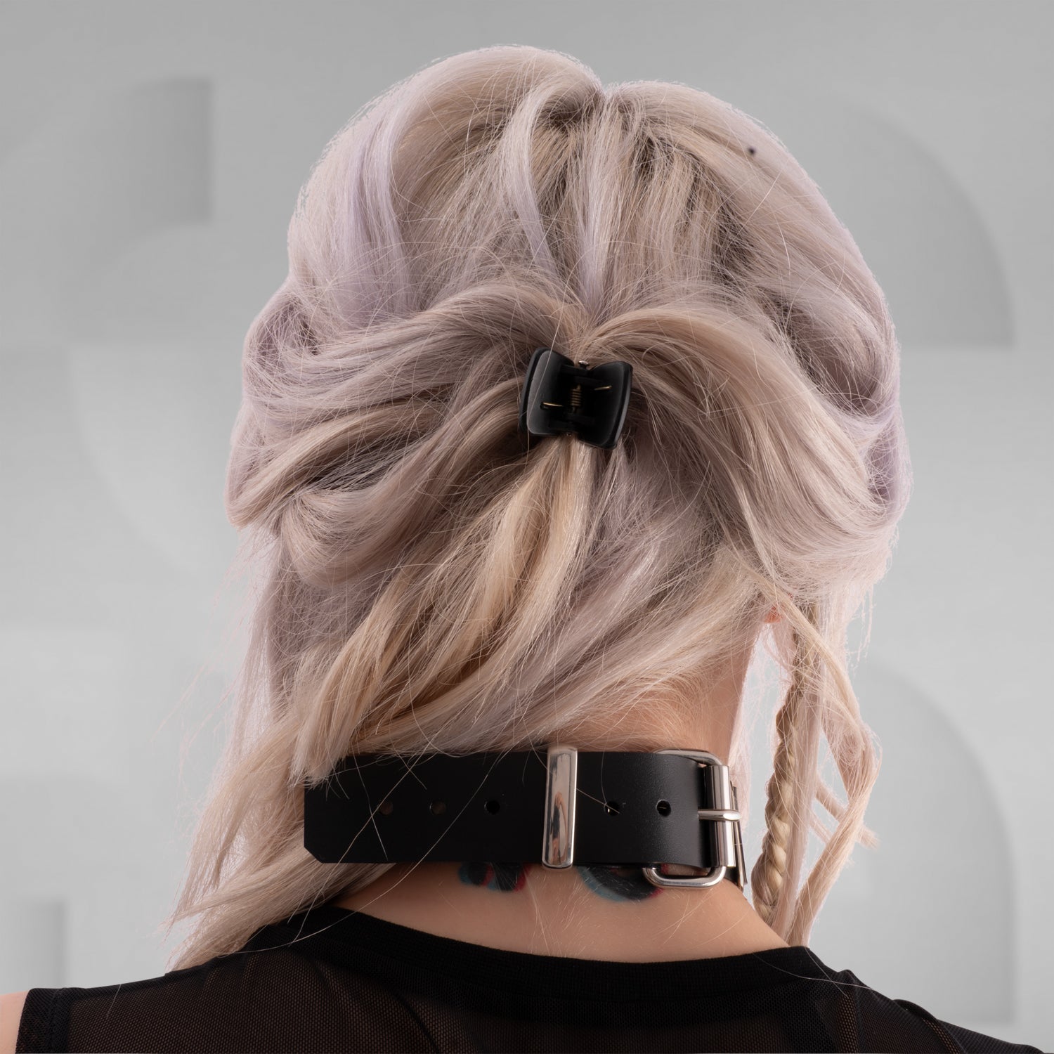 The image features an avant-garde choker with rectangular black segments linked by metal hardware. It's a bold accessory that adds a unique, edgy touch to any look, blending modern elegance with a hint of rebellion.