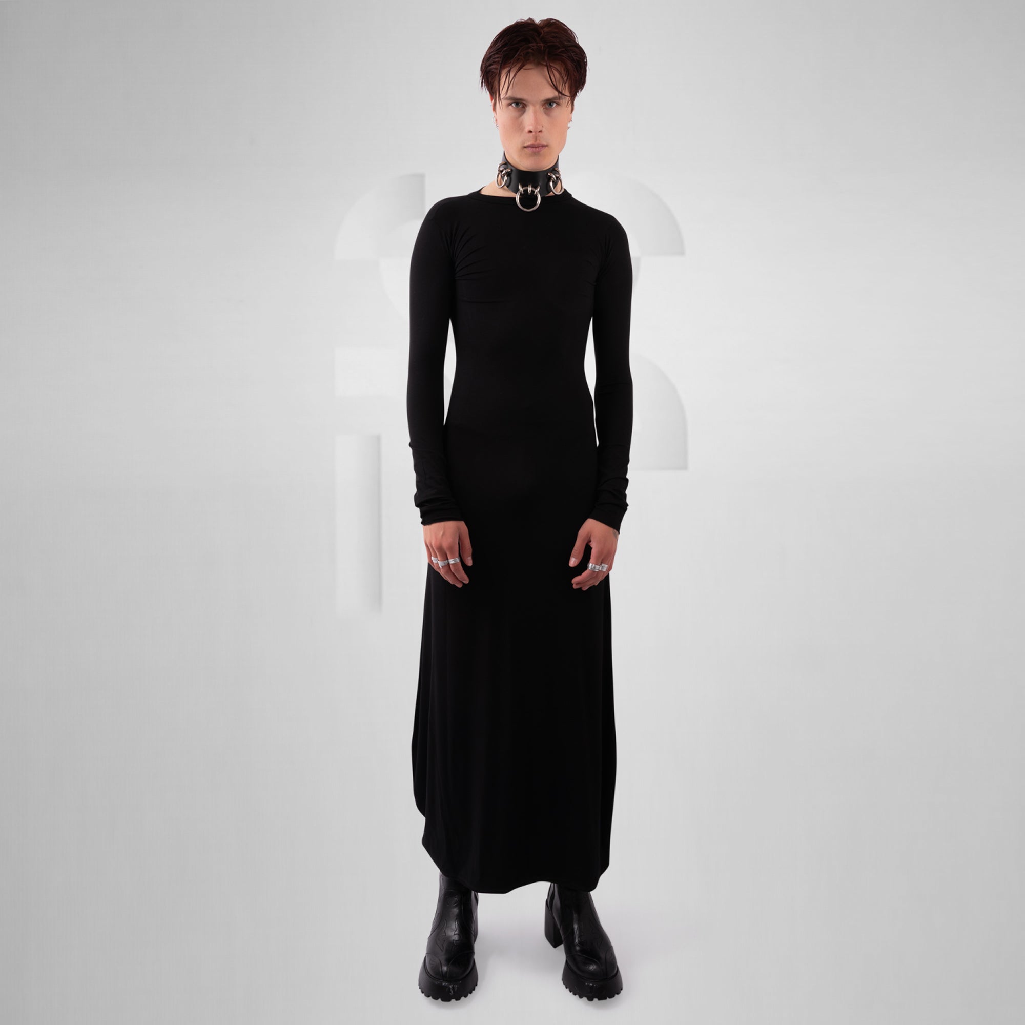 Person wearing a black dress and black shoes on a white background
