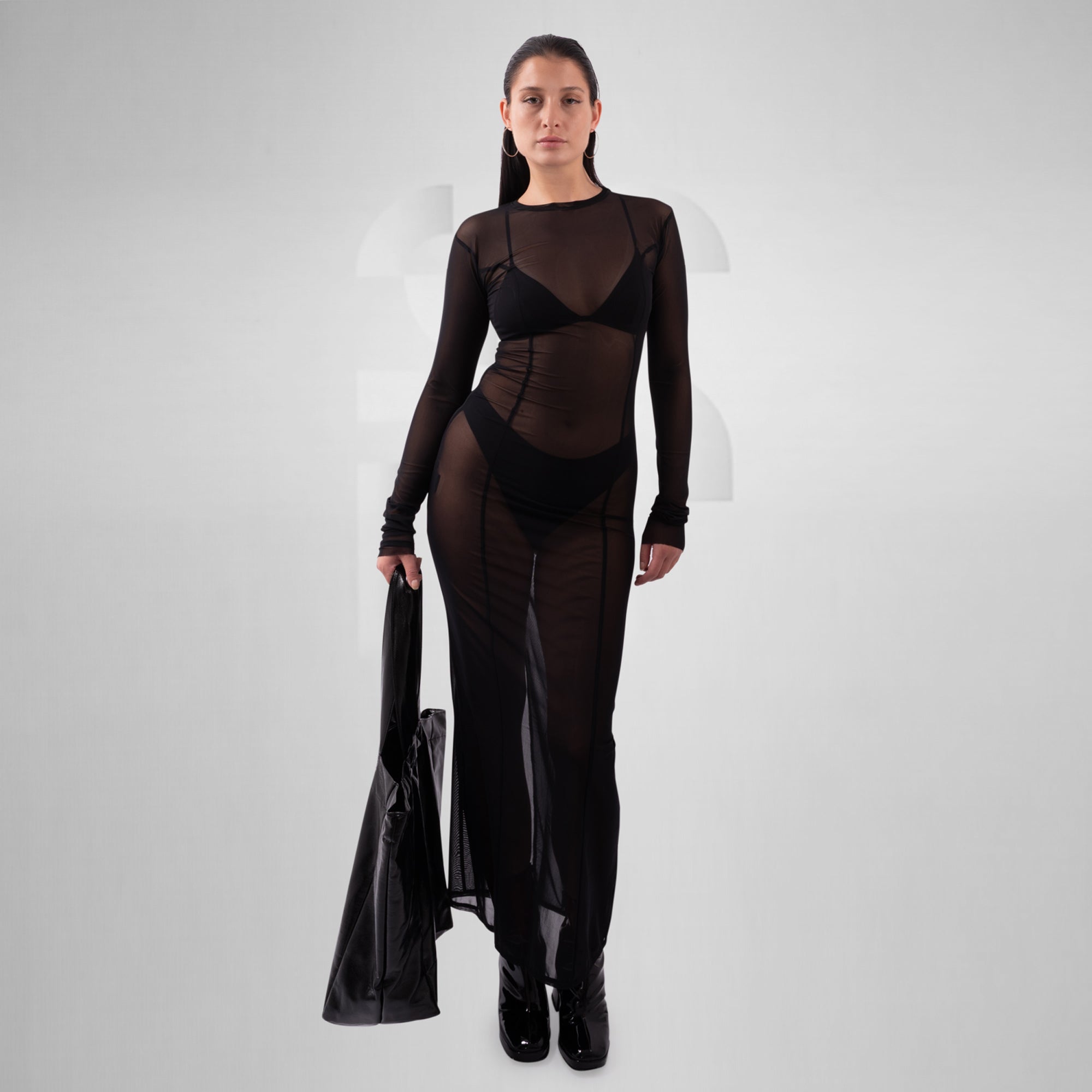 Woman wearing a black outfit with sheer panels on a white background