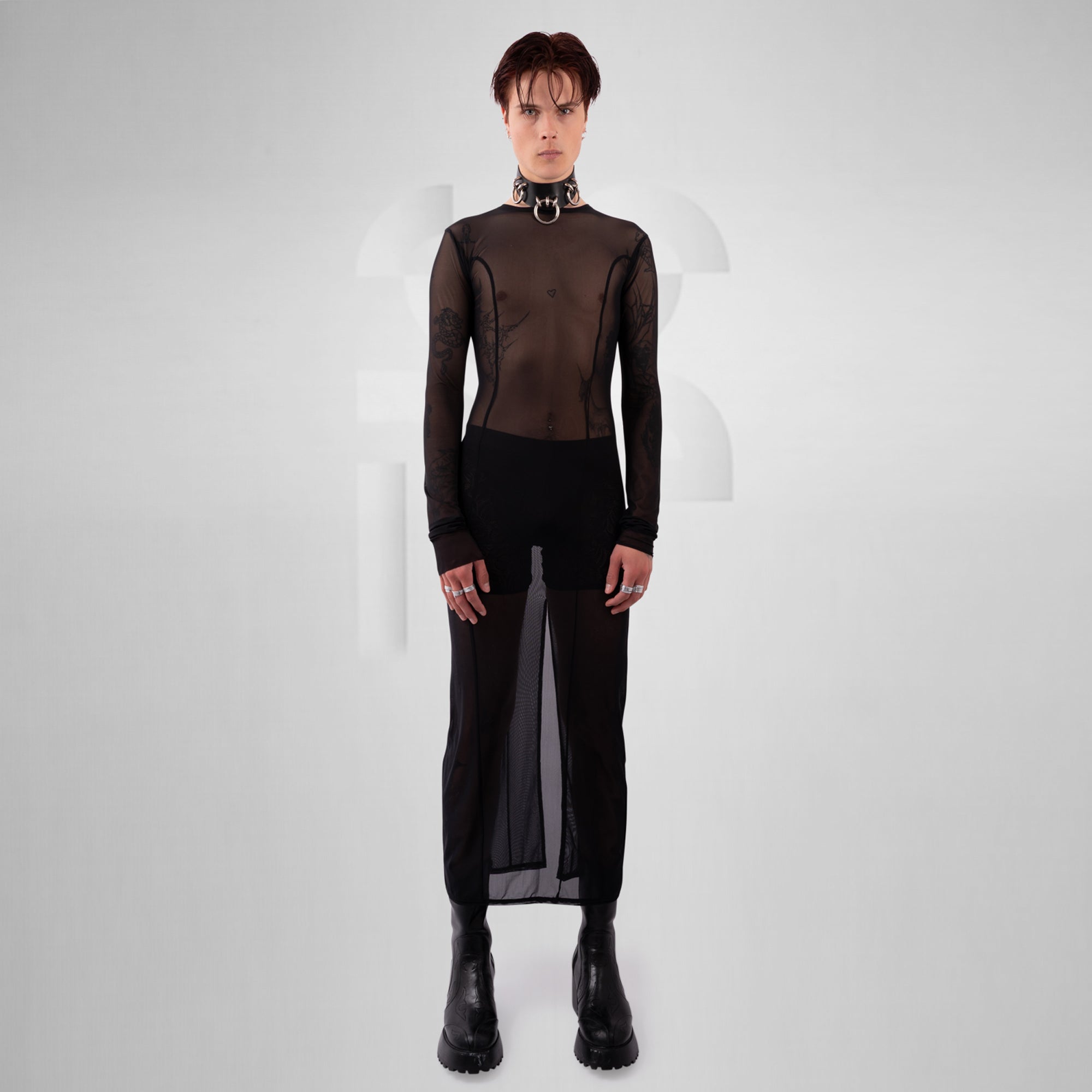Person wearing a black outfit with sheer elements on a white background