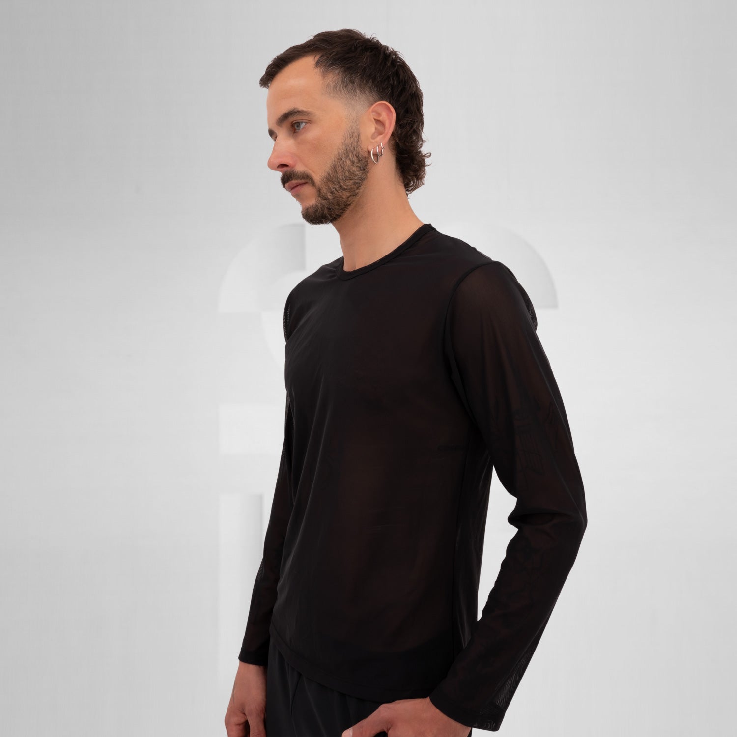 Model wearing a black mesh long sleeve top, ideal for Berlin nightlife.