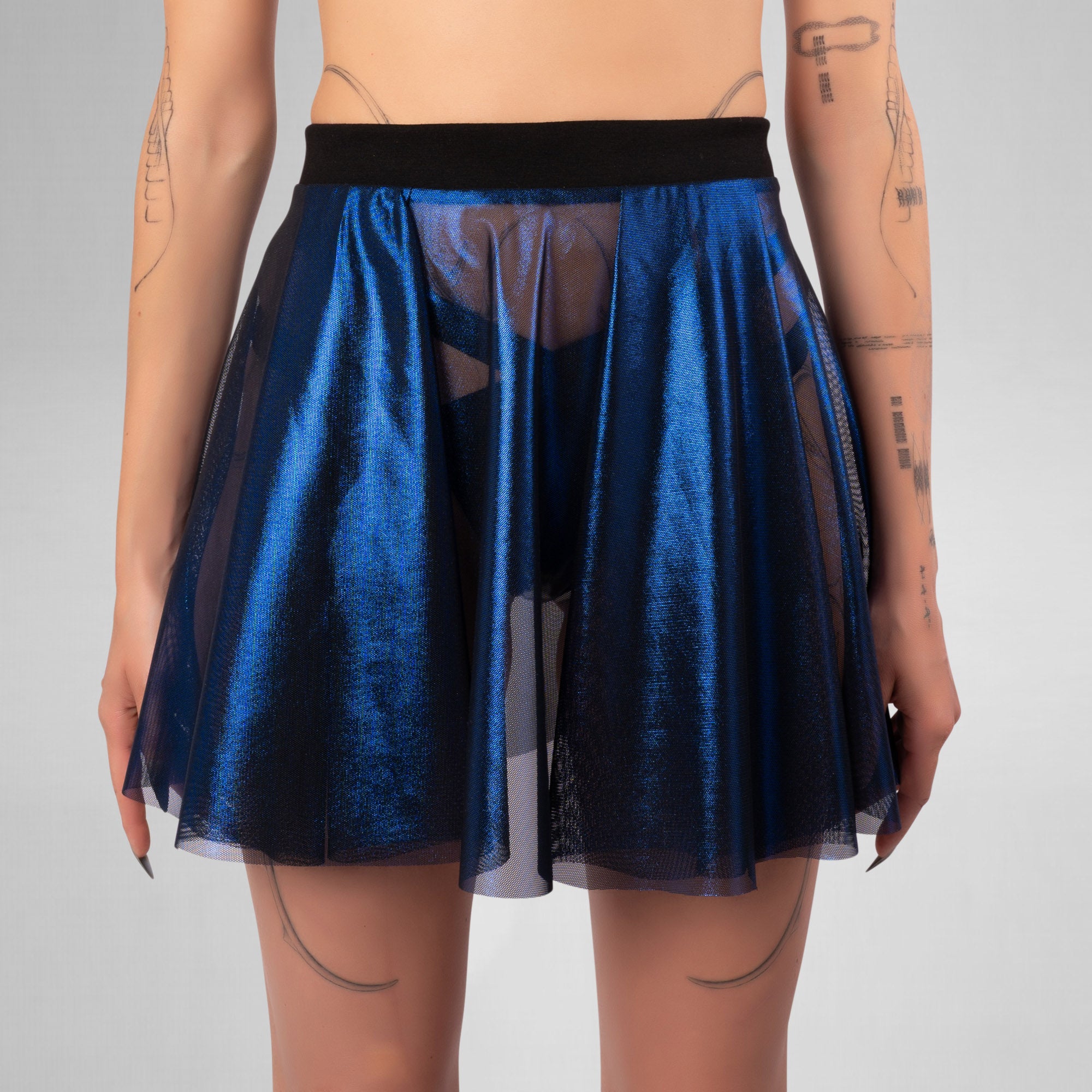 Blue metallic skirt with sheer overlay worn by a person on a gray background