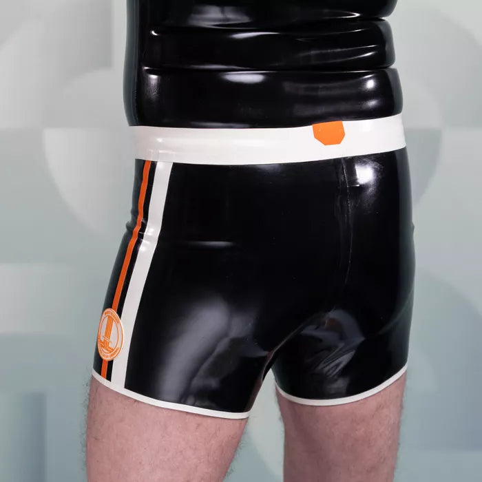 The image features sleek black shorts from HeavyTool Gear, designed for a bold and eye-catching look. The shiny latex material hugs the body, creating a striking silhouette, while the contrasting waistband adds a stylish touch. Perfect for both clubwear and performance, these shorts exude confidence and a unique sense of style.