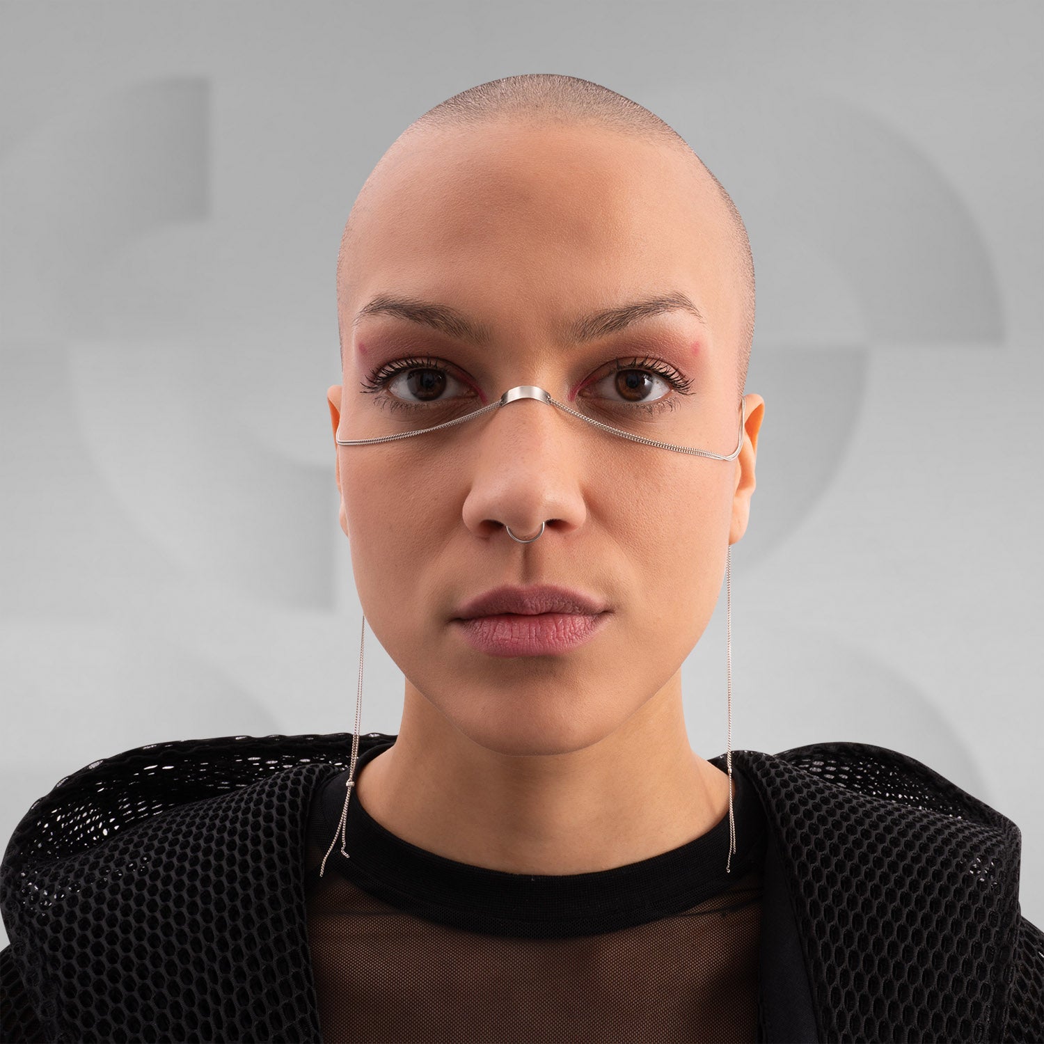 This image features someone wearing a minimalist face chain paired with a stylish mesh top and jacket. It's a sleek and modern look, perfect for making a bold fashion statement. If you're looking to elevate your style, this accessory is definitely a head-turner!