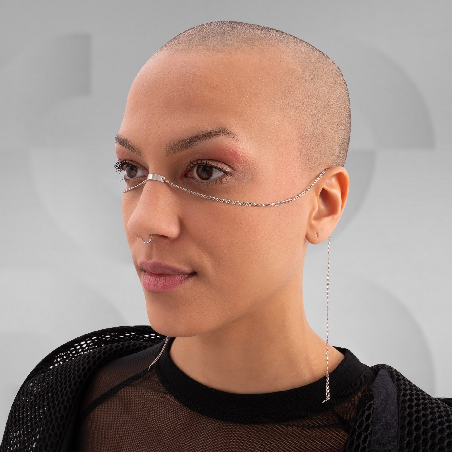 This image features someone wearing a minimalist face chain paired with a stylish mesh top and jacket. It's a sleek and modern look, perfect for making a bold fashion statement. If you're looking to elevate your style, this accessory is definitely a head-turner!