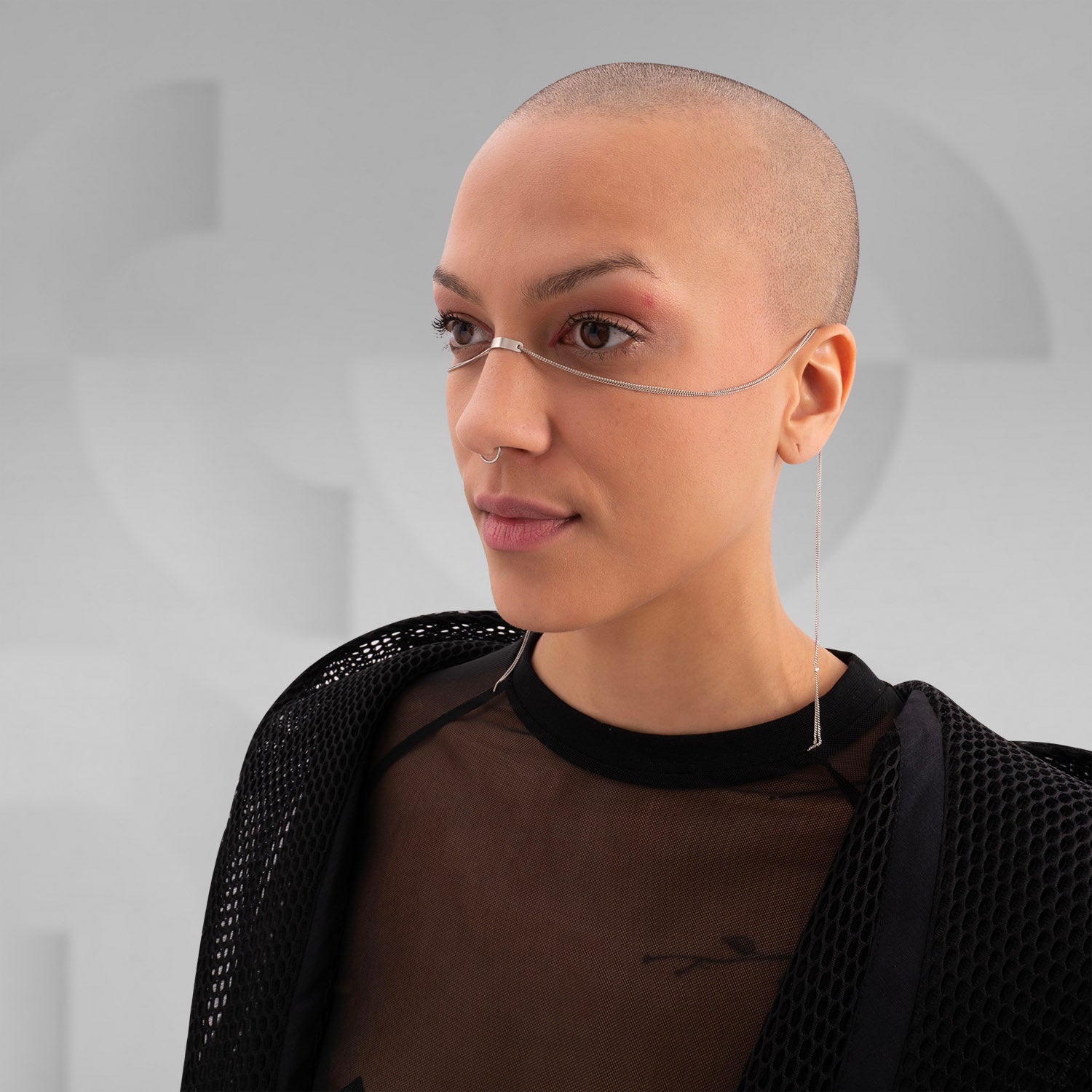 This image features someone wearing a minimalist face chain paired with a stylish mesh top and jacket. It's a sleek and modern look, perfect for making a bold fashion statement. If you're looking to elevate your style, this accessory is definitely a head-turner!