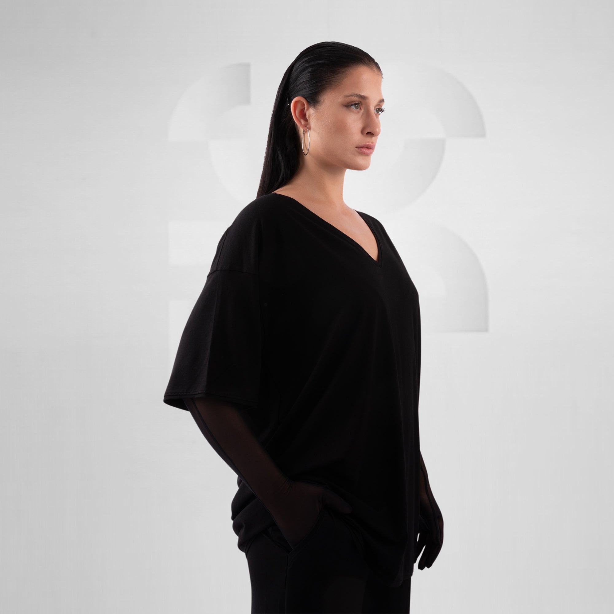 Woman wearing a black outfit against a white background