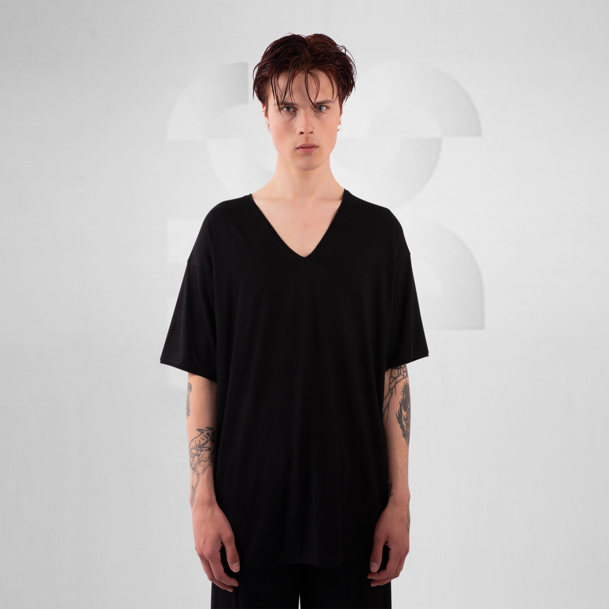Person wearing a black oversized t-shirt against a plain background