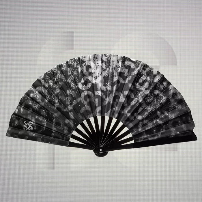 The Printed Dance Floor Fan from The Code showcases a captivating design that blends bold black and textured patterns, making it a stunning accessory for any night out. This fan not only serves a practical purpose, providing a refreshing breeze as you dance, but also elevates your style with its artistic flair. Lightweight and portable, it easily complements your clubwear, allowing you to express your individuality while keeping cool