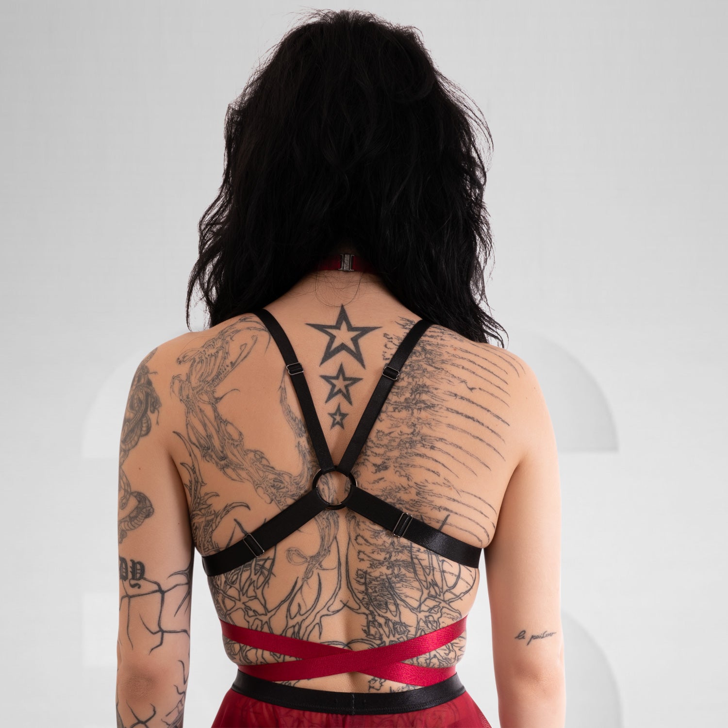 A bold choker harness in red, that features a striking choker neckline and sleek strap details around the waist.