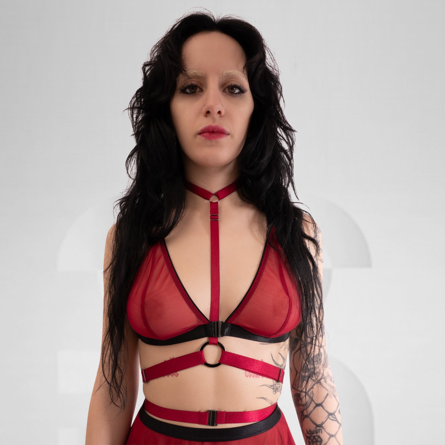 A bold choker harness in red, that features a striking choker neckline and sleek strap details around the waist.