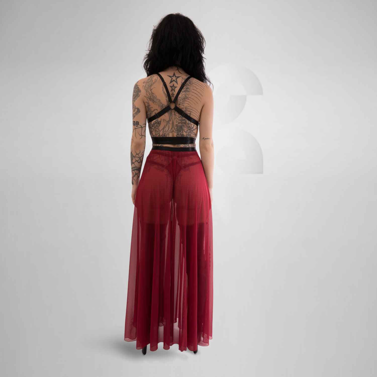 The vibrant red hue intensifies the long mesh skirt's seductive appeal, creating a visually arresting piece that demands attention. Its long length gracefully flows down to the floor, providing a captivating and sophisticated look. The fabric embraces the wearer's curves, accentuating her feminine shape while remaining comfortable to wear.