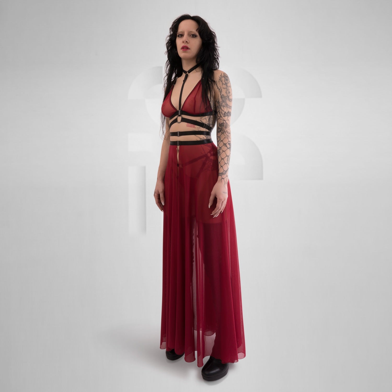 The vibrant red hue intensifies the long mesh skirt's seductive appeal, creating a visually arresting piece that demands attention. Its long length gracefully flows down to the floor, providing a captivating and sophisticated look. The fabric embraces the wearer's curves, accentuating her feminine shape while remaining comfortable to wear.