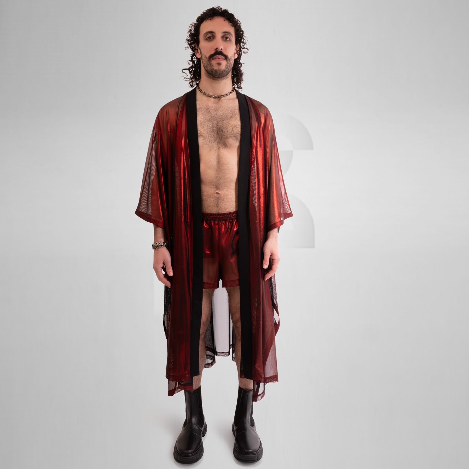 A striking long poncho in red, blue, and silver with a shiny disco festival vibe.