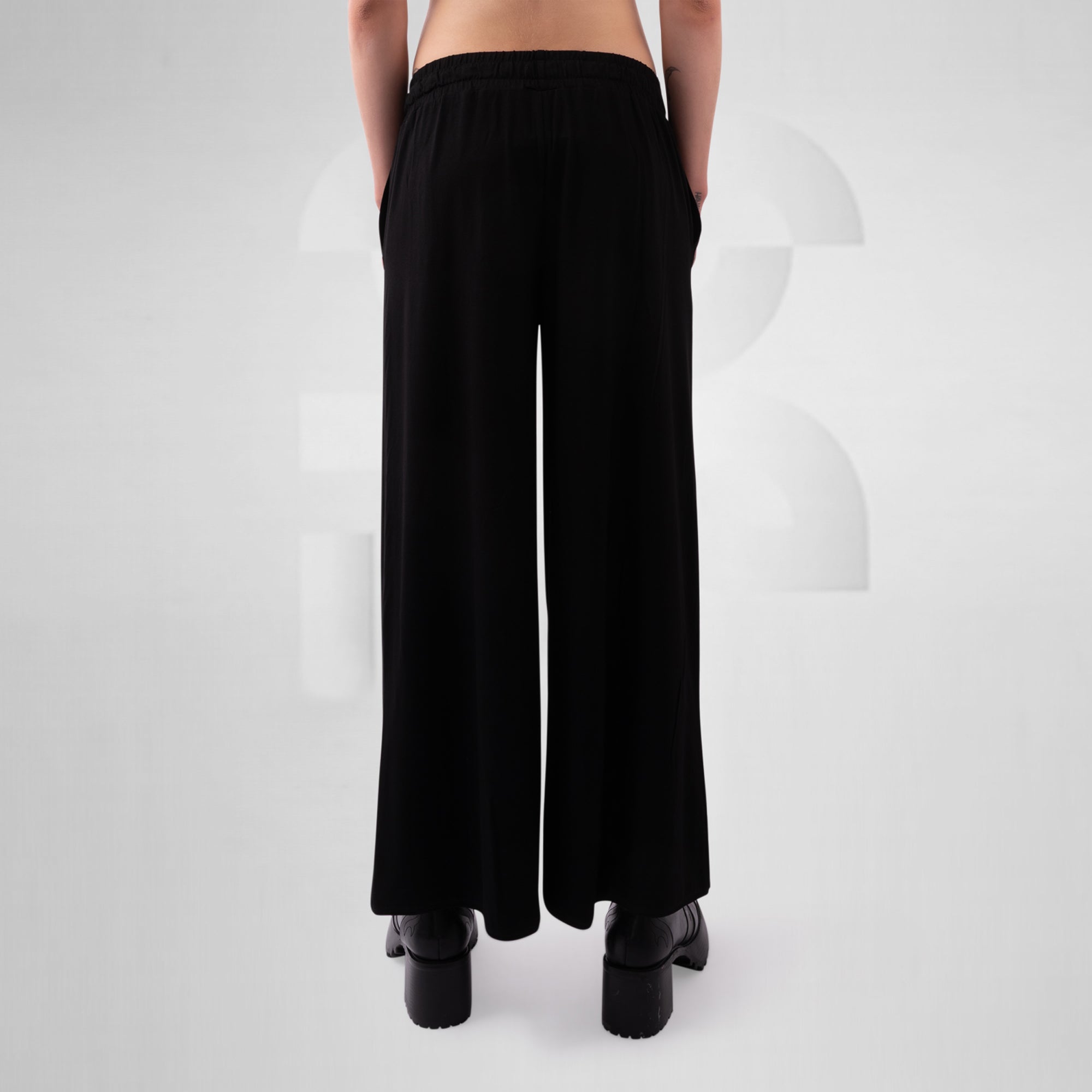 Black wide-leg pants worn by a person on a white background
