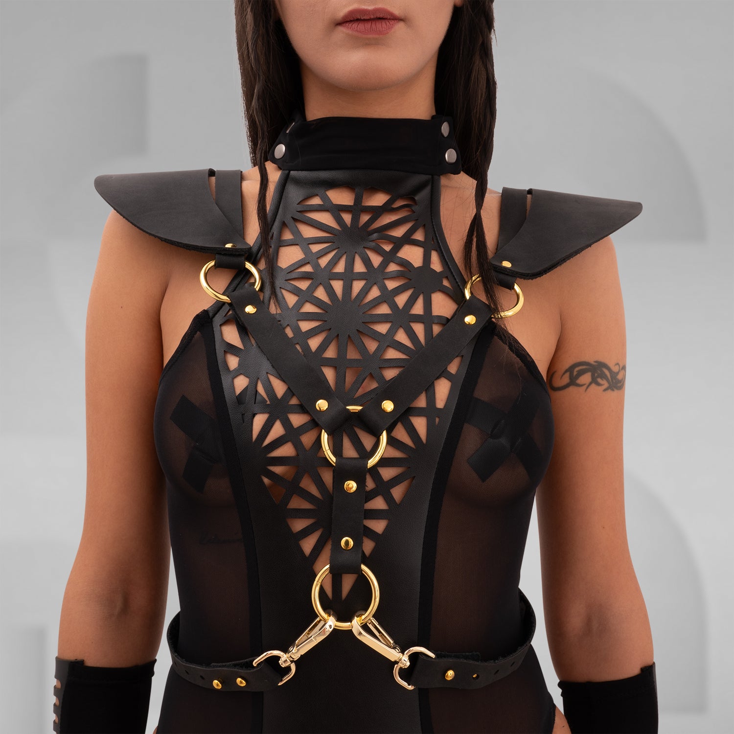 The Laser Cut Harness with Shoulder Details from designer Cyberesque is a daring fusion of avant-garde fashion and functionality. This eye-catching harness features intricate laser-cut designs that draw attention and elevate your outfit to new heights. With striking gold hardware and chic shoulder accents, it’s perfect for festivals, clubwear, and tribal gatherings. Designed for those who embrace their individuality and confidence, this piece transforms any ensemble into a bold statement that captures the e