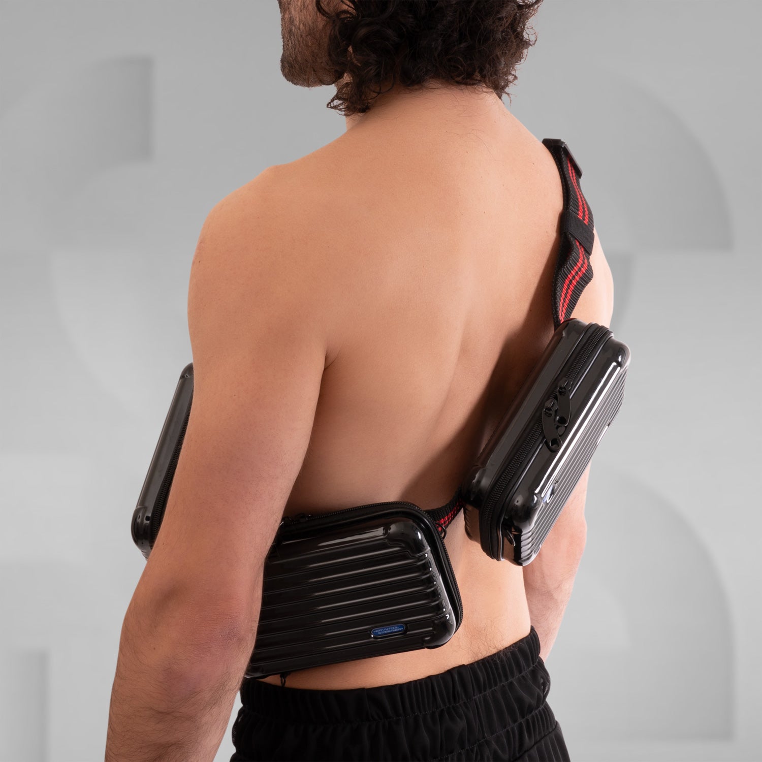 The image features a stylish Suitcase Crossbody Bag in a distinctive black design. This trendy bag is worn over the shoulder, offering a modern and functional look. Its sleek casing and practical compartments make it ideal for those who appreciate both fashion and utility while on the go.