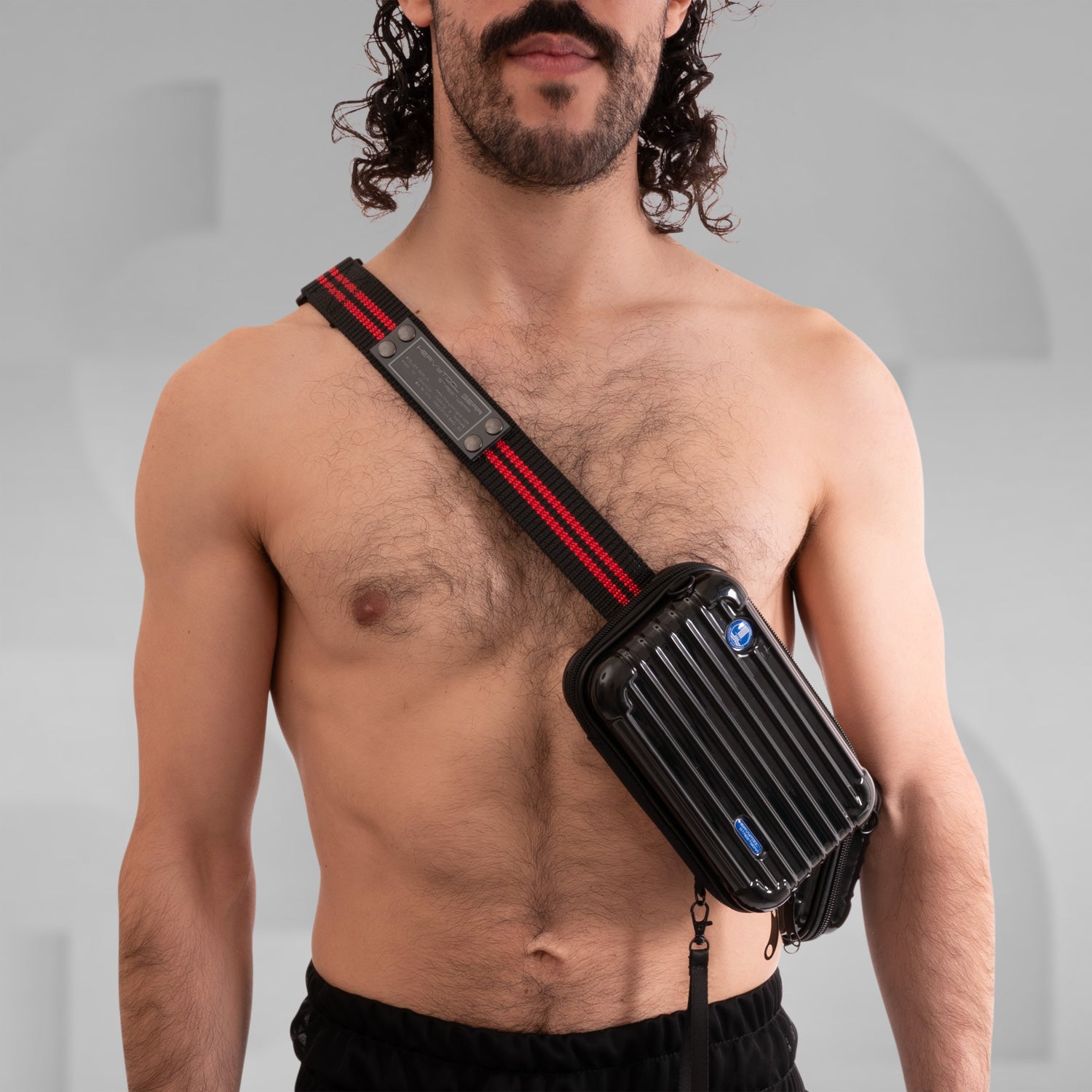 The image features a stylish Suitcase Crossbody Bag in a distinctive black design. This trendy bag is worn over the shoulder, offering a modern and functional look. Its sleek casing and practical compartments make it ideal for those who appreciate both fashion and utility while on the go.