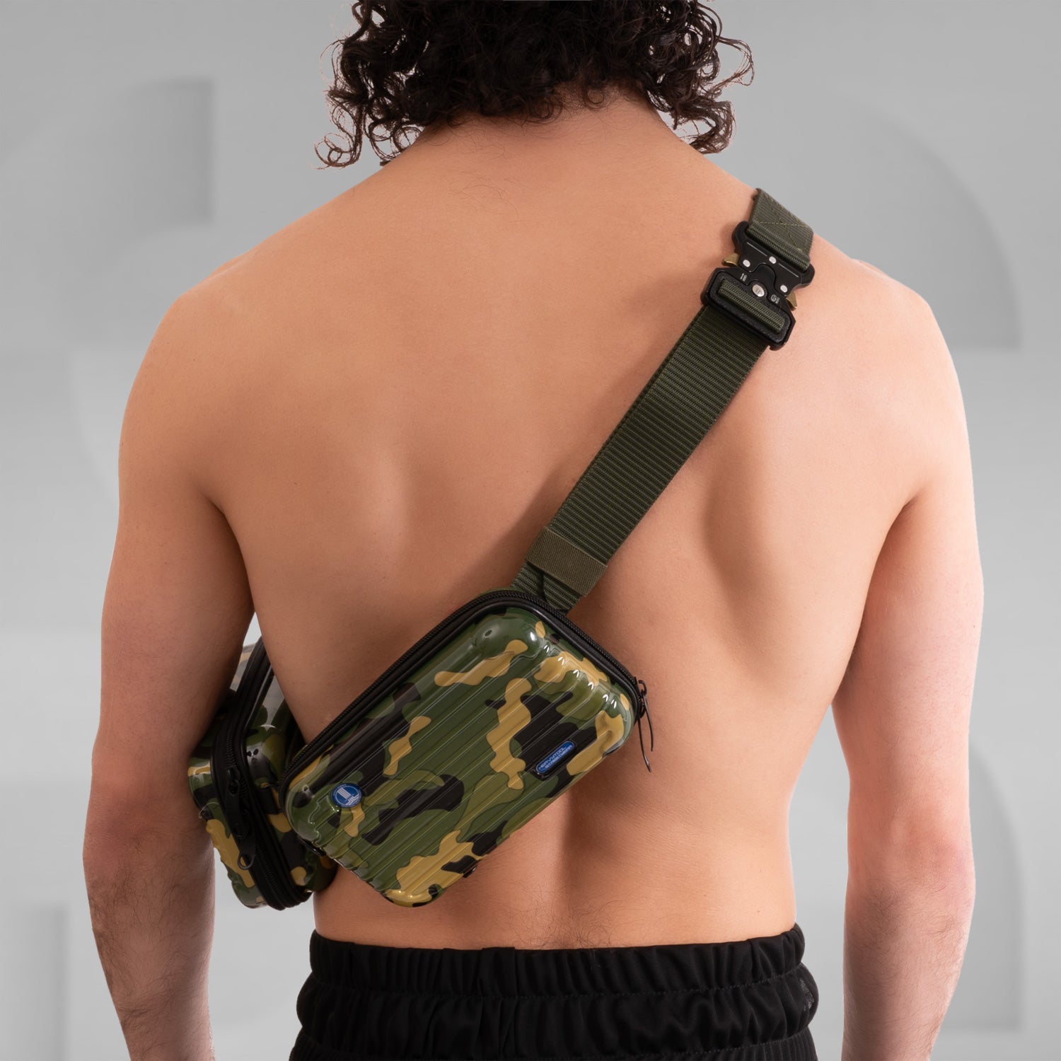 The image features a stylish Suitcase Crossbody Bag in a distinctive camouflage design. This trendy bag is worn over the shoulder, offering a modern and functional look. Its sleek casing and practical compartments make it ideal for those who appreciate both fashion and utility while on the go.