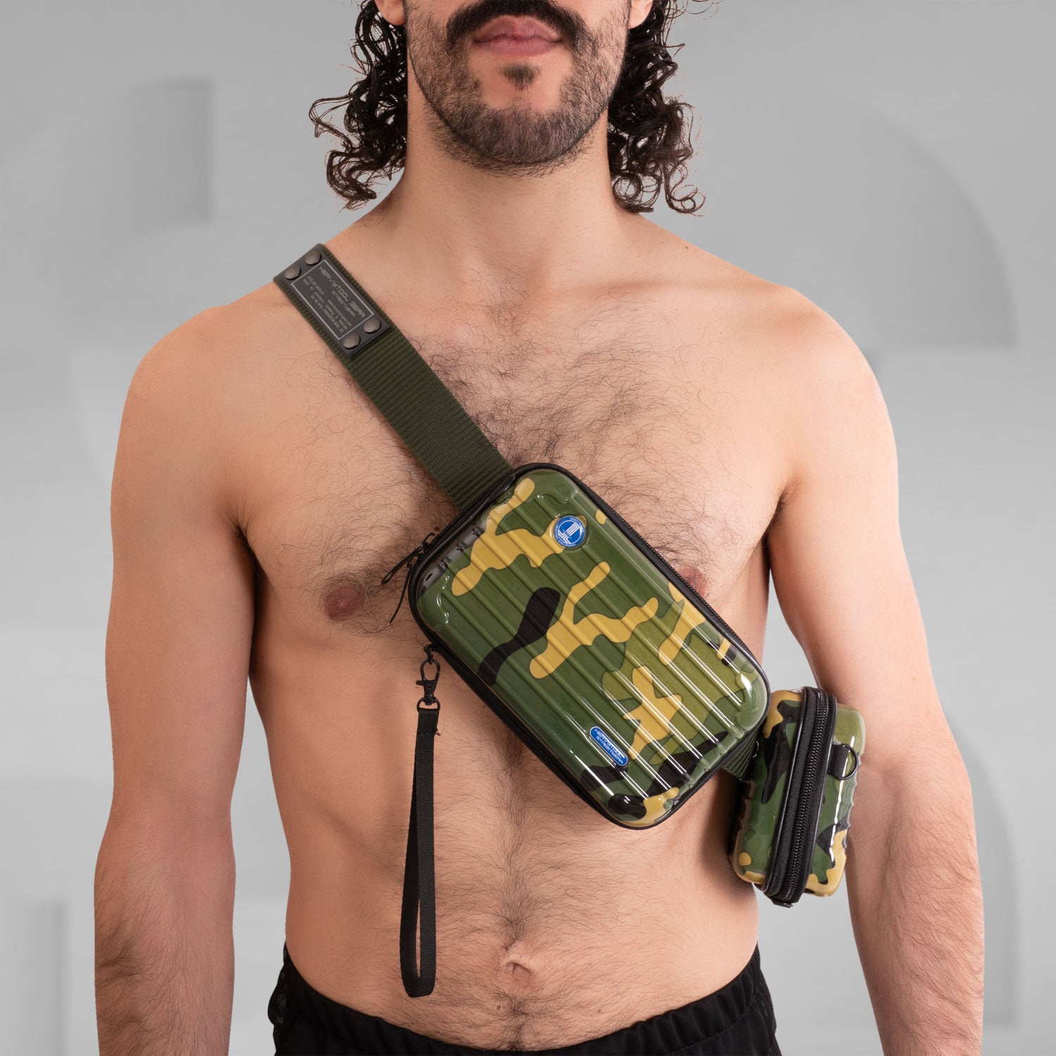 The image features a stylish Suitcase Crossbody Bag in a distinctive camouflage design. This trendy bag is worn over the shoulder, offering a modern and functional look. Its sleek casing and practical compartments make it ideal for those who appreciate both fashion and utility while on the go.