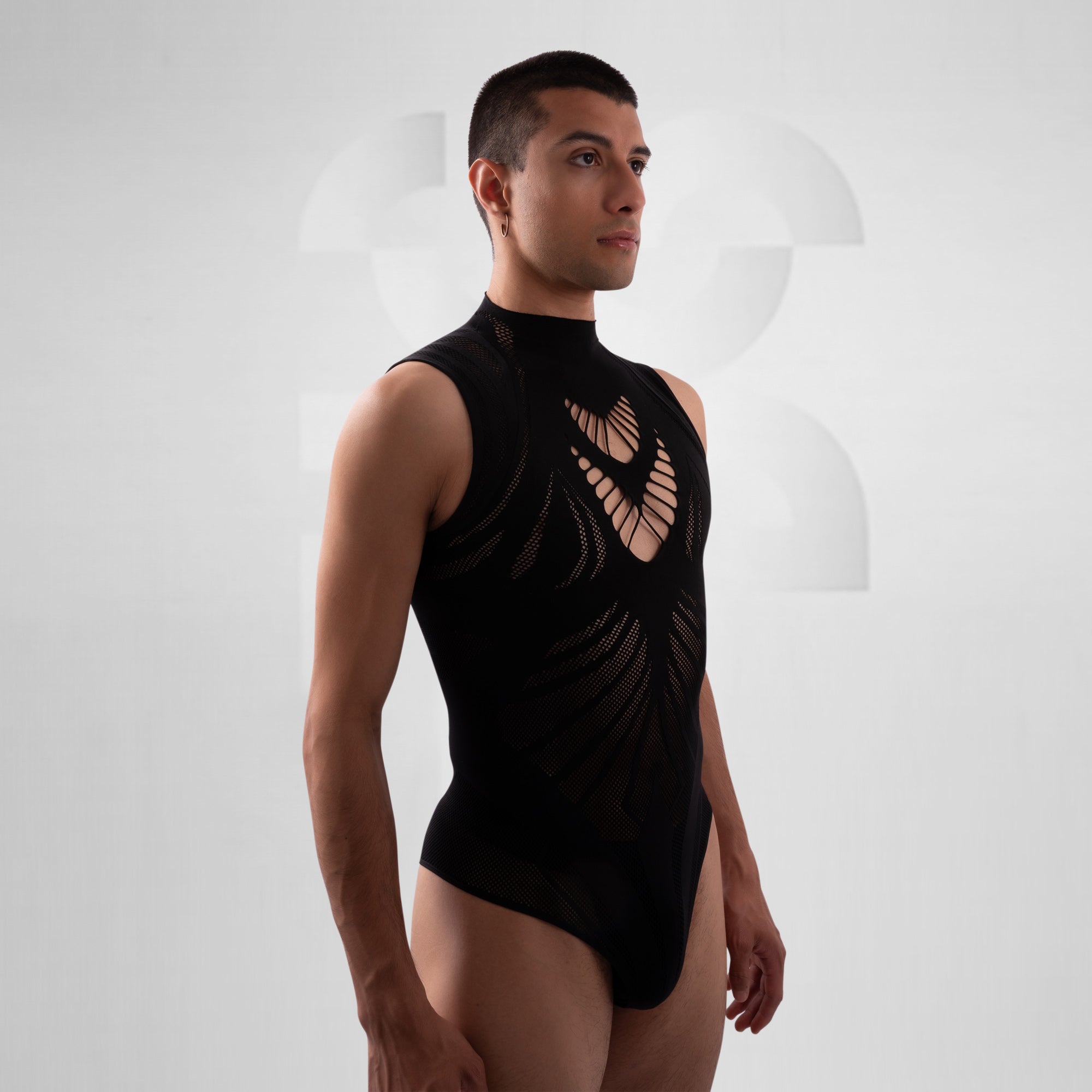 Man wearing a black sleeveless leotard with cut-out design on a white background