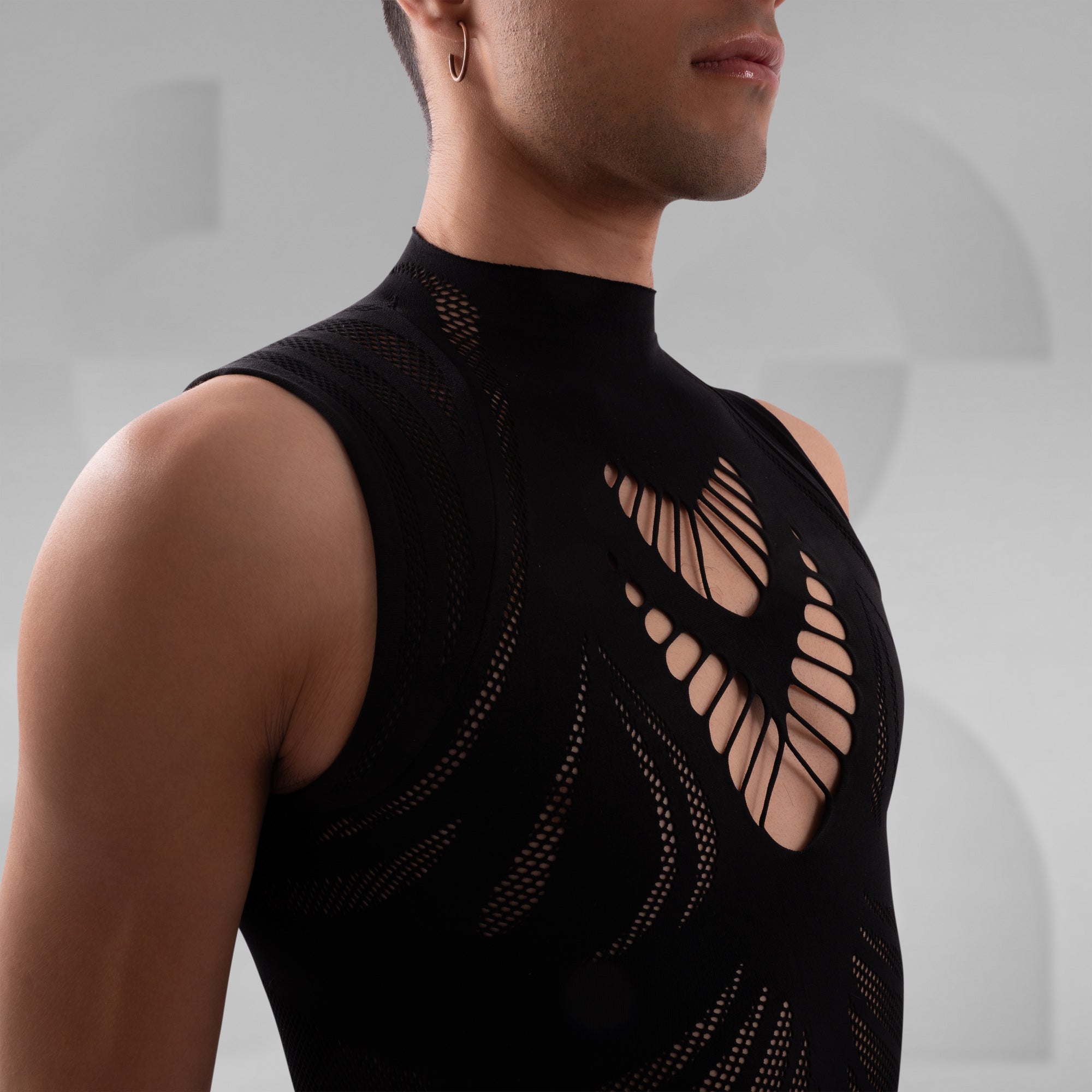 Black sleeveless top with cut-out design on a neutral background