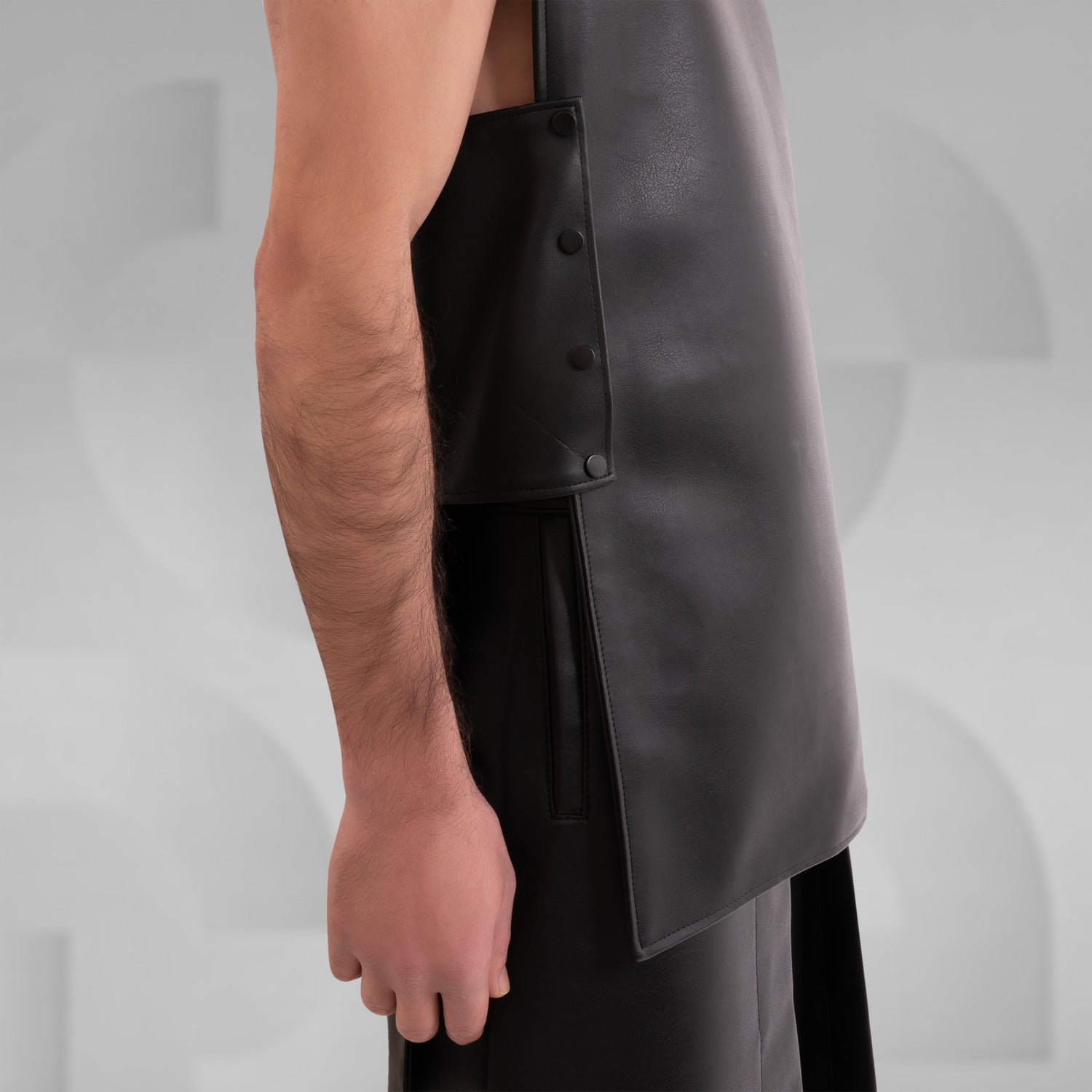 A close-up image of a faux leather vest with an avantgarde geometric design.