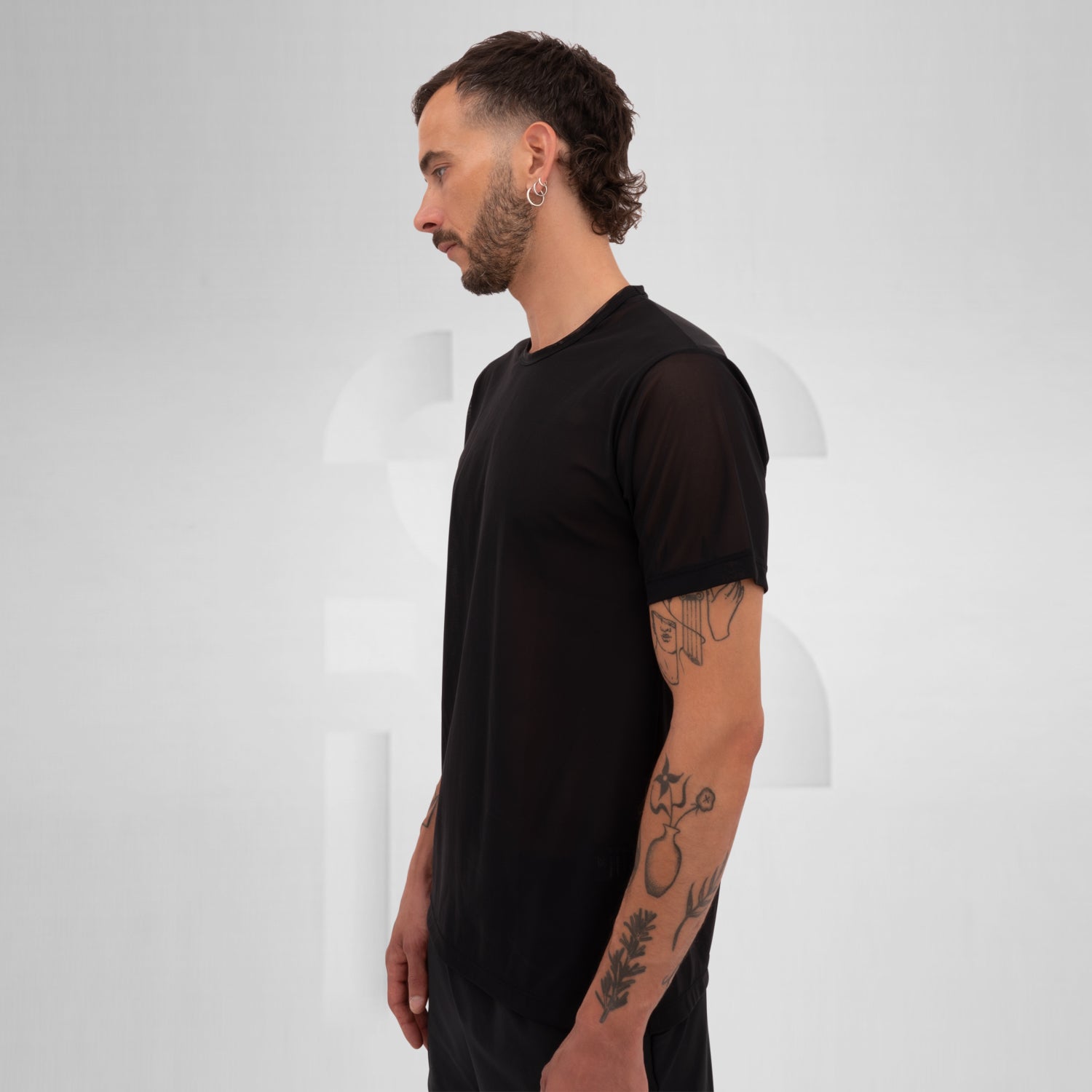 Model showcasing a black mesh short sleeve top, perfect for Berlin nightlife.