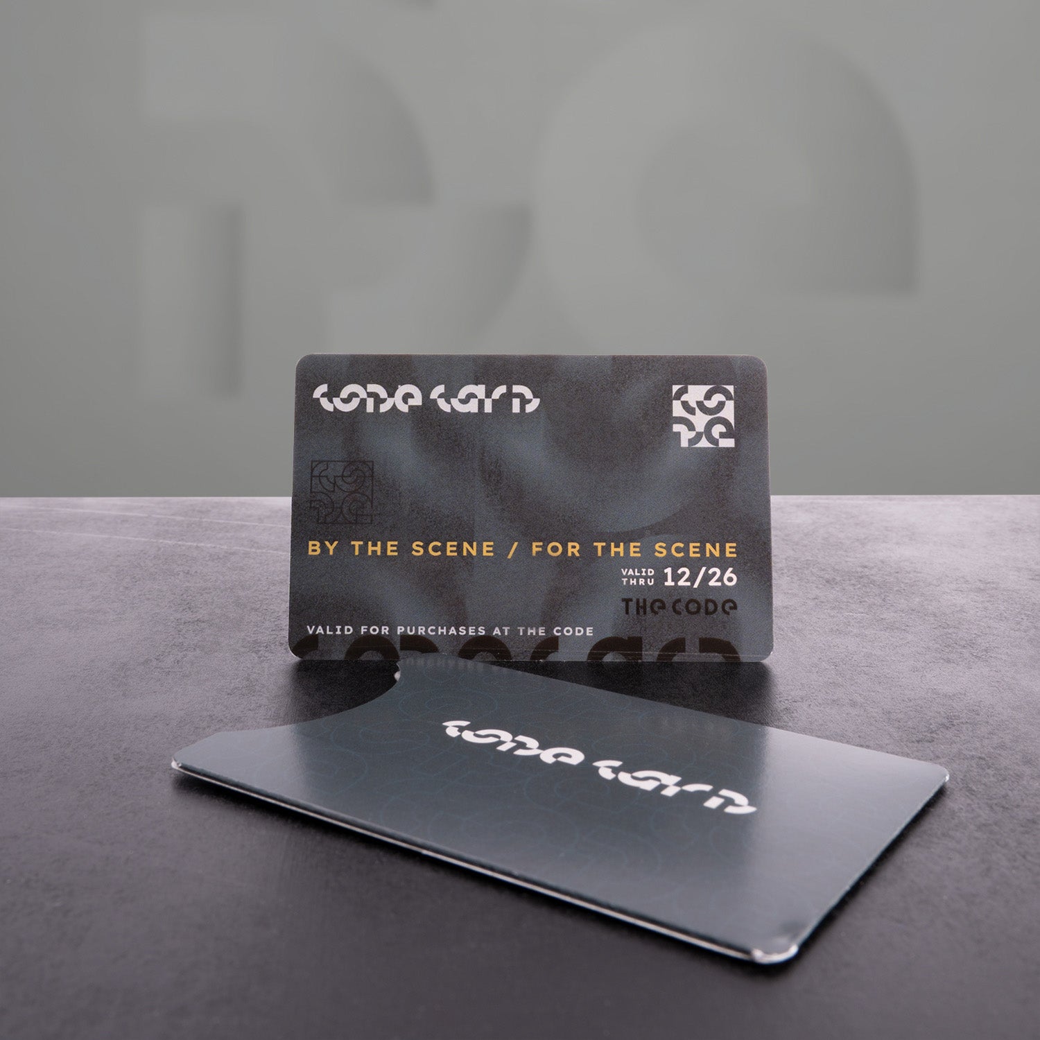 The image showcases two stylish cards designed with a modern aesthetic. One card is displayed upright, while the other lies flat, emphasizing a sleek and contemporary look. The sophisticated design and unique branding make these cards eye-catching, perfect for enhancing customer experience and engagement in retail or promotional settings.