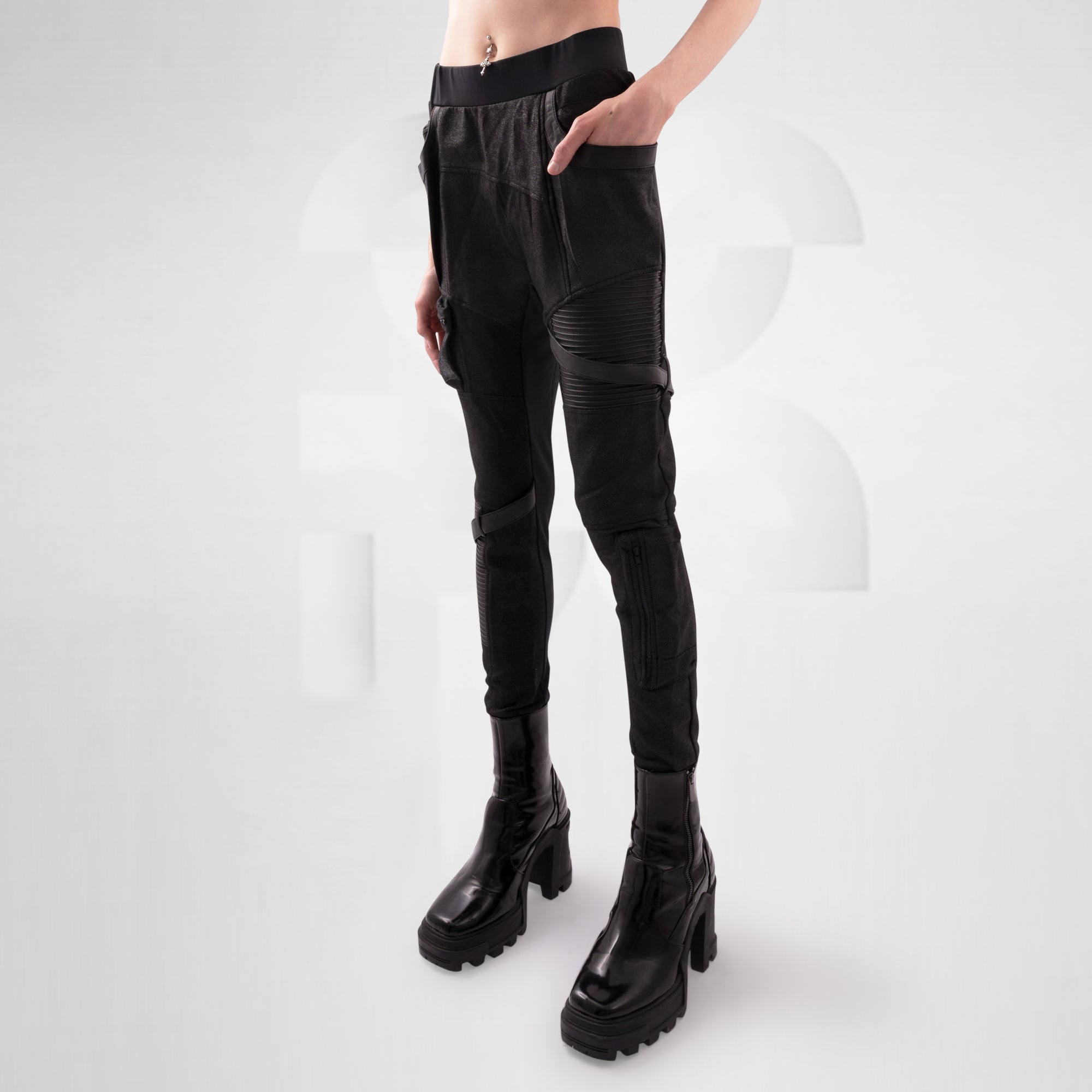 Black leather pants with zippers worn by a person on a white background