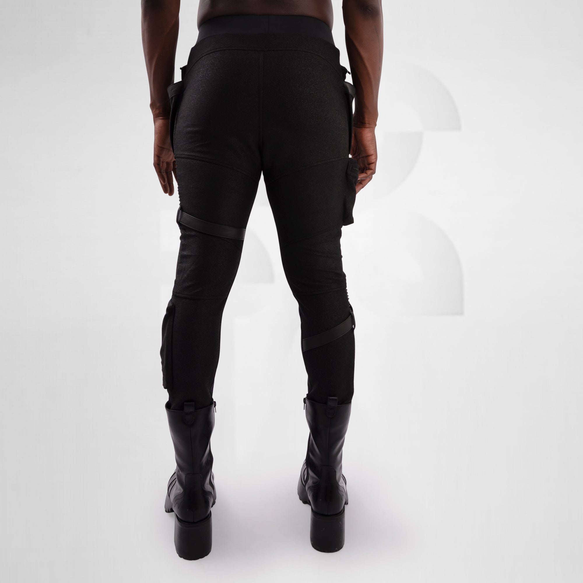 Person wearing black pants and boots on a white background