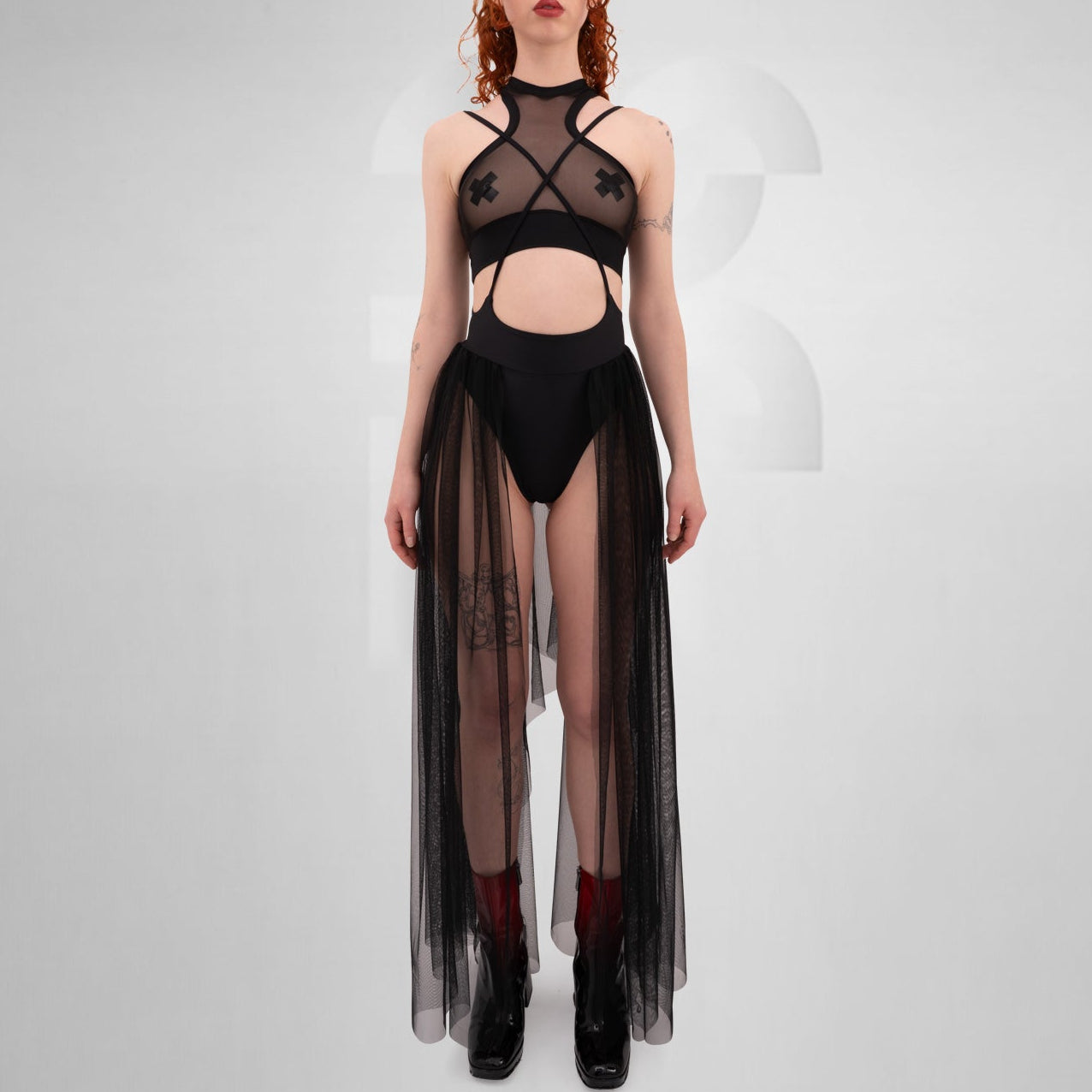 Model wearing a black sheer tulle skirt with thigh-high slits, styled for a Berlin-inspired techno clubwear look.