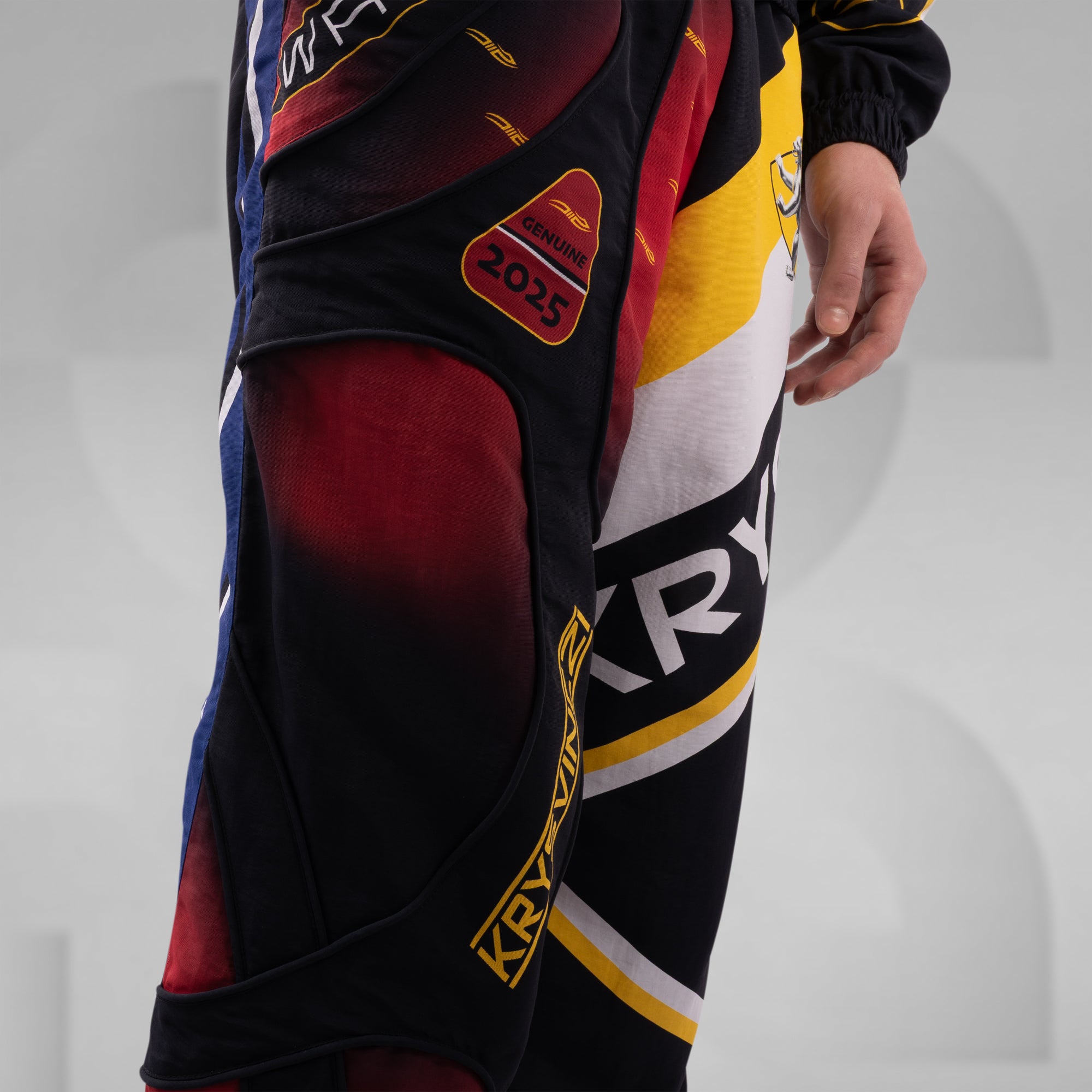 Close-up of a person wearing a colorful sports outfit with visible branding on a light gray background