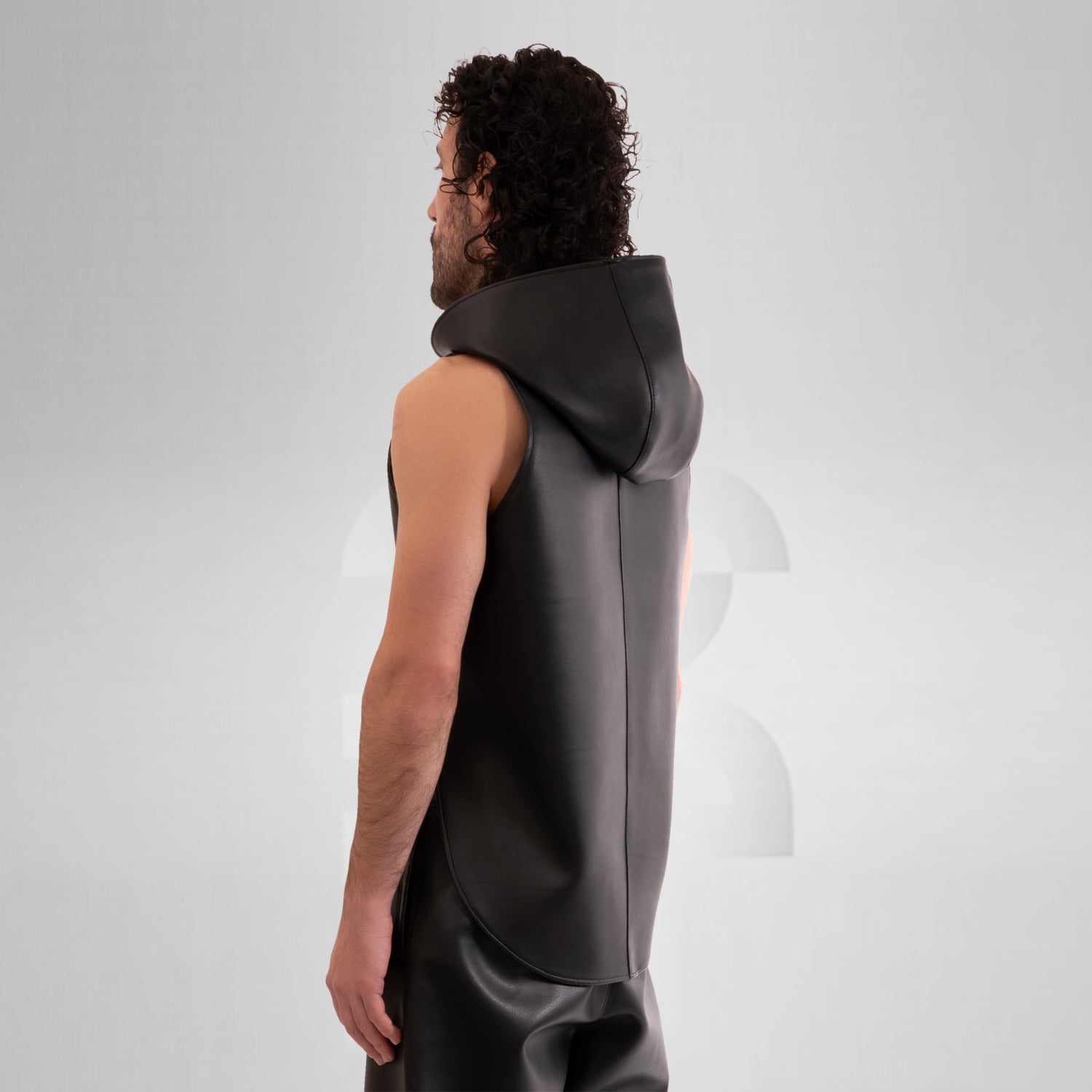 The Vegan Leather Cropped Hoodie by This is Fred features a striking design that combines tribal-inspired elements with a contemporary avant-garde aesthetic. The model showcases this unique piece, which is both bold and eye-catching. Crafted from animal-friendly materials, the hoodie offers comfort and a sense of style that’s perfect for festivals or as an audacious addition to everyday outfits. Its cropped silhouette and distinctive hood create a fashion-forward look that truly makes a statement.