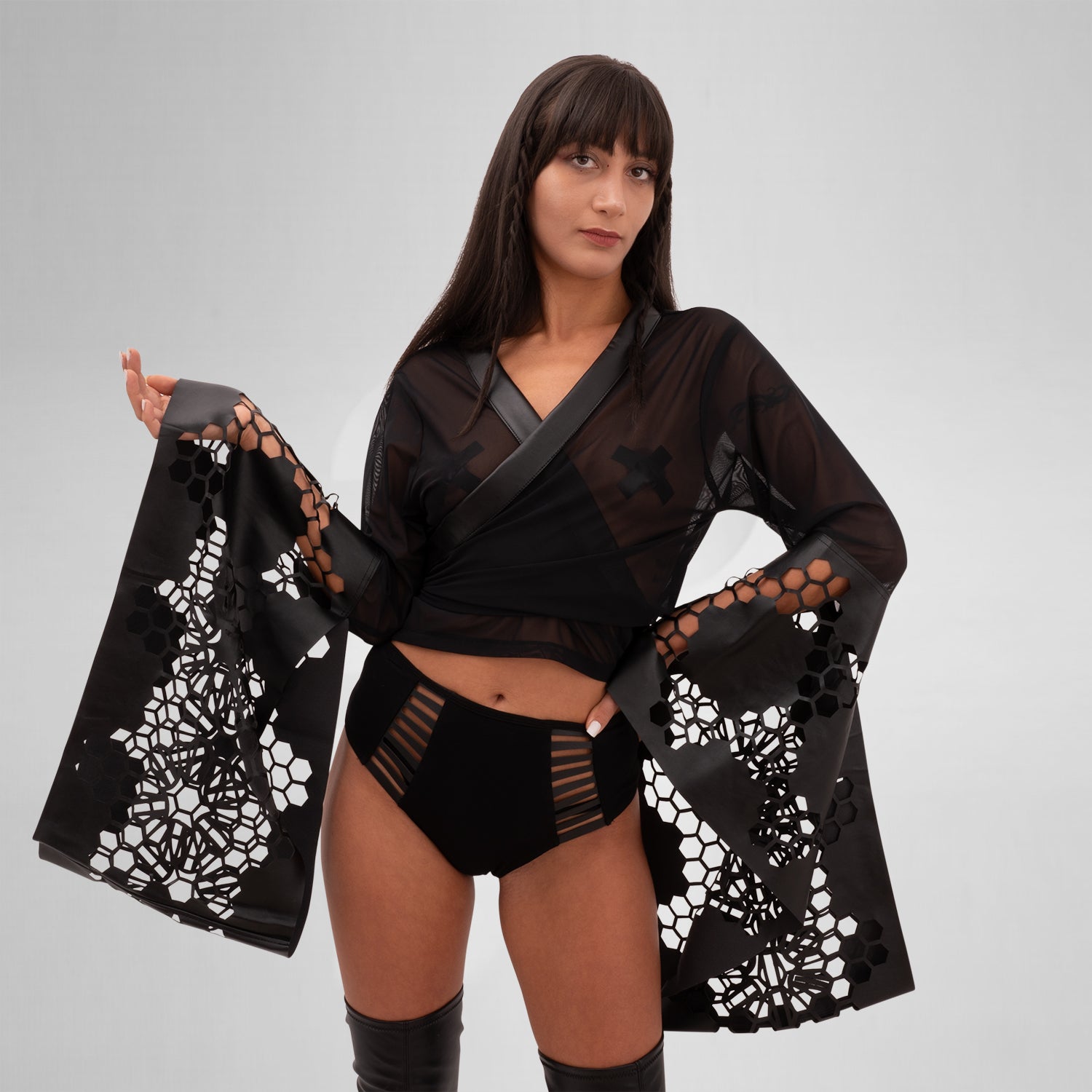 The Printed Sheer Kimono from Cyberesque is a stunning blend of elegance and edgy design. Featuring intricate laser-cut detailing on the sleeves and hem, this kimono adds a bold flair to any outfit. Crafted from lightweight, sheer fabric, it drapes beautifully, making it perfect for layering over clubwear or swimwear. Ideal for those who want to make a statement at festivals or embrace avant-garde fashion.