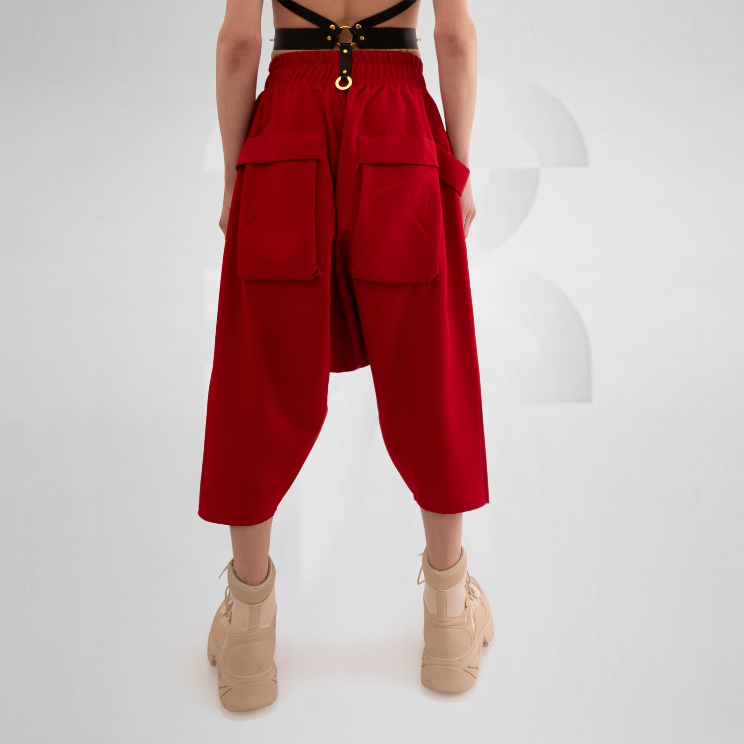 The Wide Trousers with Straps Mixed from This is Fred showcase a bold red hue and an avant-garde design that commands attention. The adjustable straps not only lend a unique twist to the silhouette but also allow for a customizable fit. Practical pockets enhance functionality, making these trousers the perfect fusion of style and utility. Paired with chunky boots, they create a striking outfit that is both contemporary and creative, ideal for expressing your unique fashion sense.