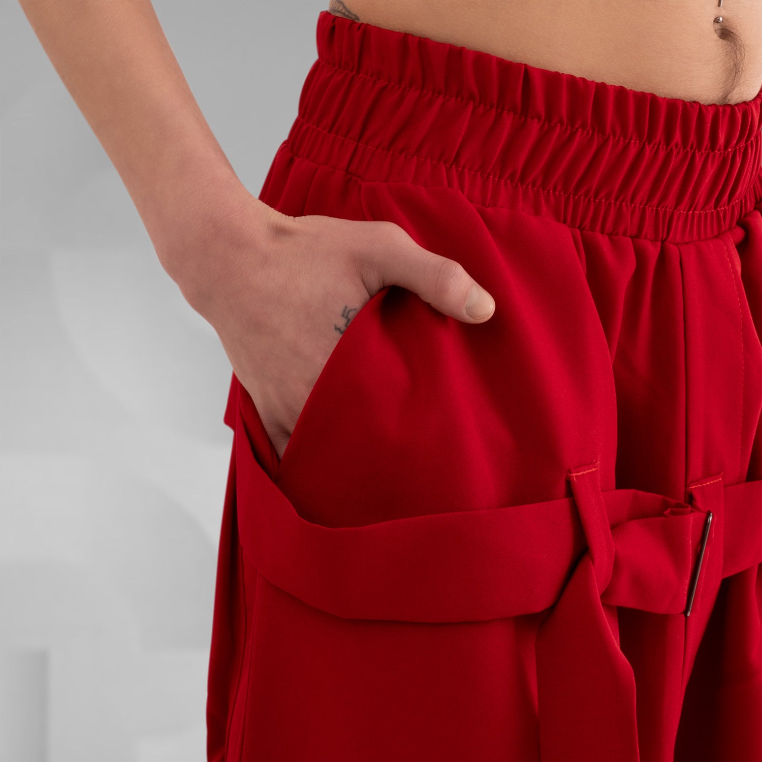 The Wide Trousers with Straps Mixed from This is Fred showcase a bold red hue and an avant-garde design that commands attention. The adjustable straps not only lend a unique twist to the silhouette but also allow for a customizable fit. Practical pockets enhance functionality, making these trousers the perfect fusion of style and utility. Paired with chunky boots, they create a striking outfit that is both contemporary and creative, ideal for expressing your unique fashion sense.