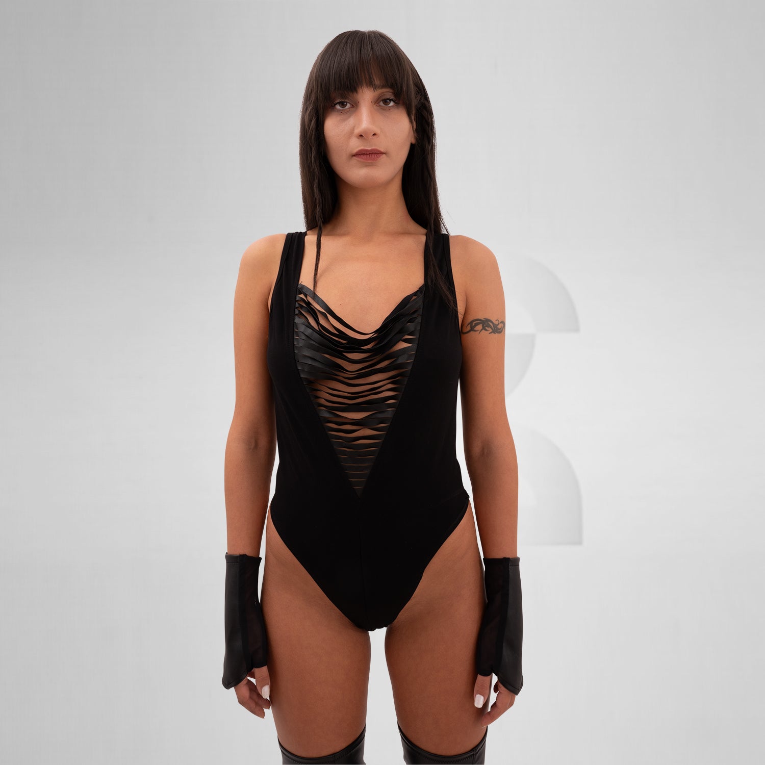 Avant-garde body crafted from cotton, vegan leather, and elastane, featuring bold straps, sleek design, and discreet snap closures.