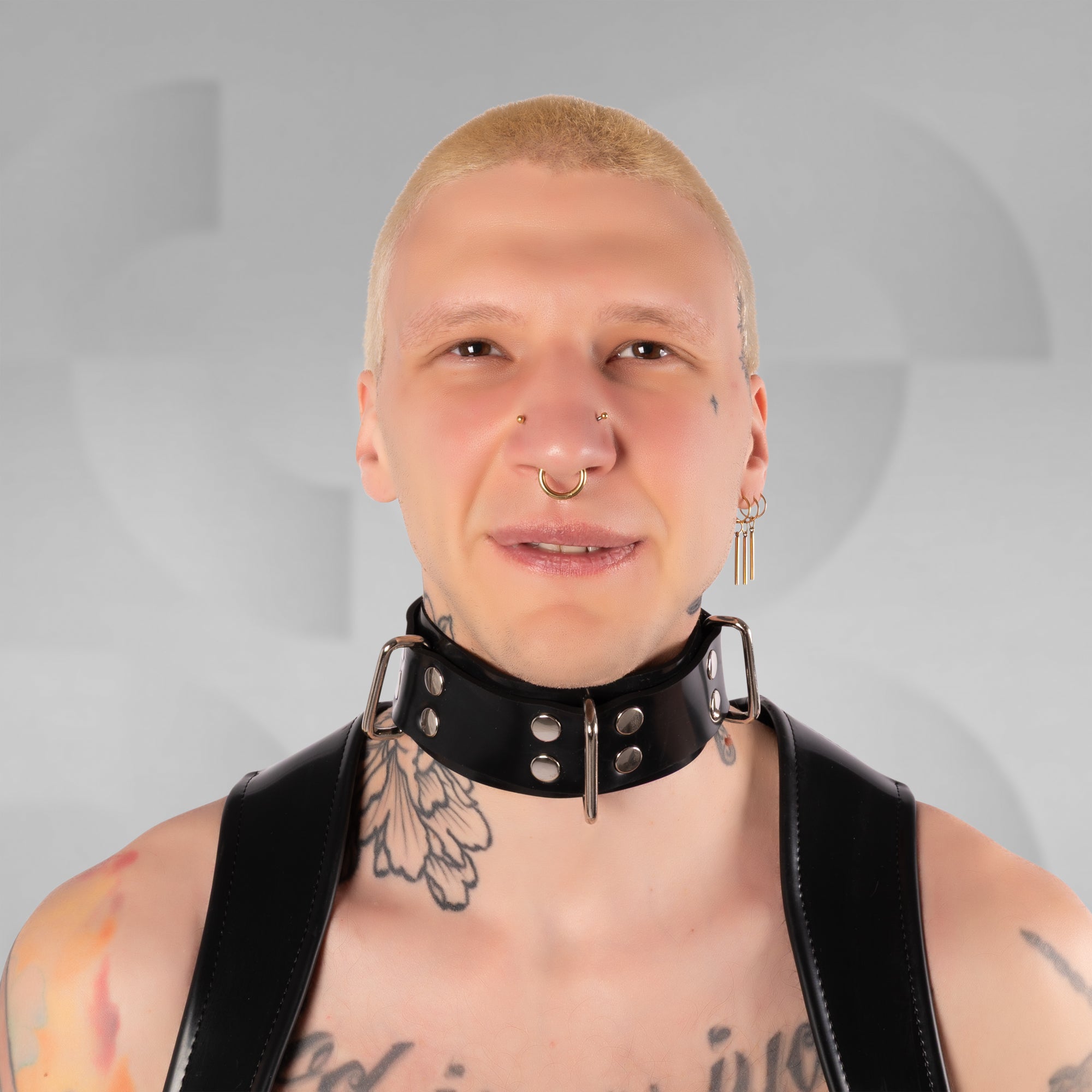 Person wearing a black choker with metal accents on a gray background