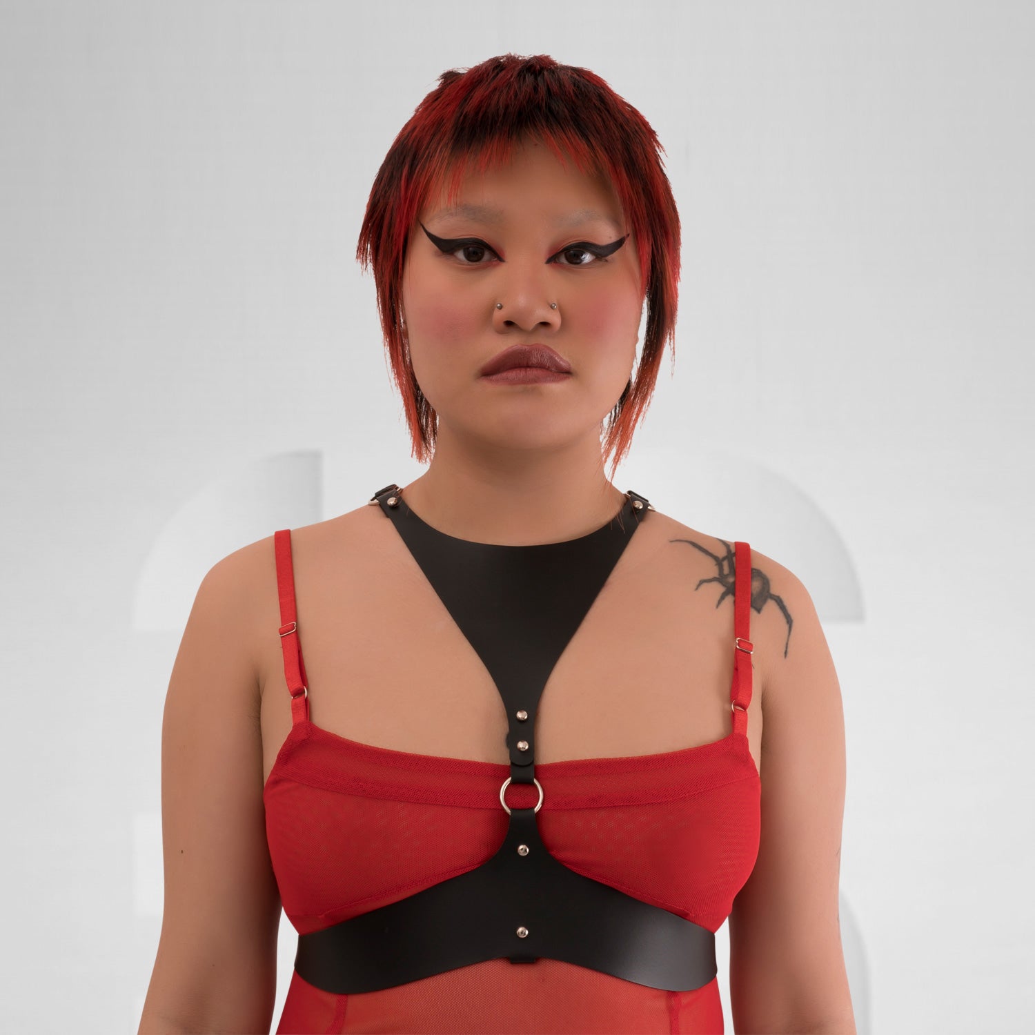 Faux leather harness sculpting the body in avantgarde clubwear style