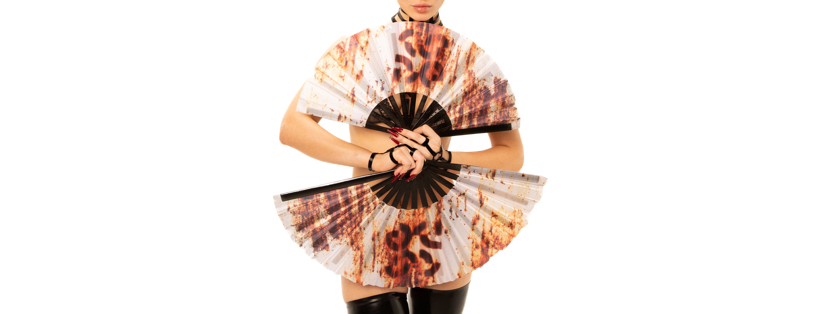 image of a model holding a large, decorative fan featuring a bold leopard print design. The model is styled in minimal attire, allowing the fan to be the focal point. Their hands are adorned with striking nail art, enhancing the overall bold aesthetic. The clean white background emphasizes the vivid details of the fan and the model's confident pose.