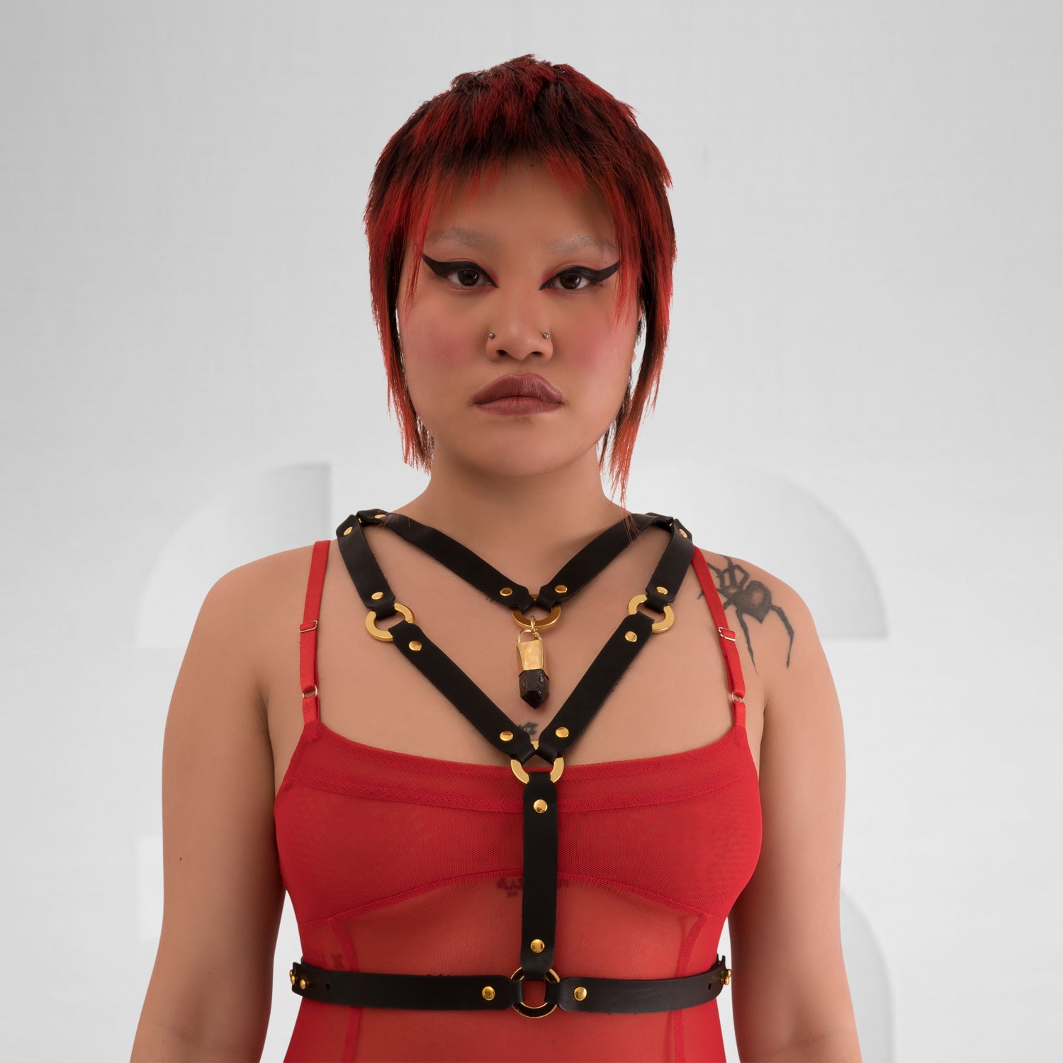 Vegan leather harness with metallic rings and crystal pendant in the center front