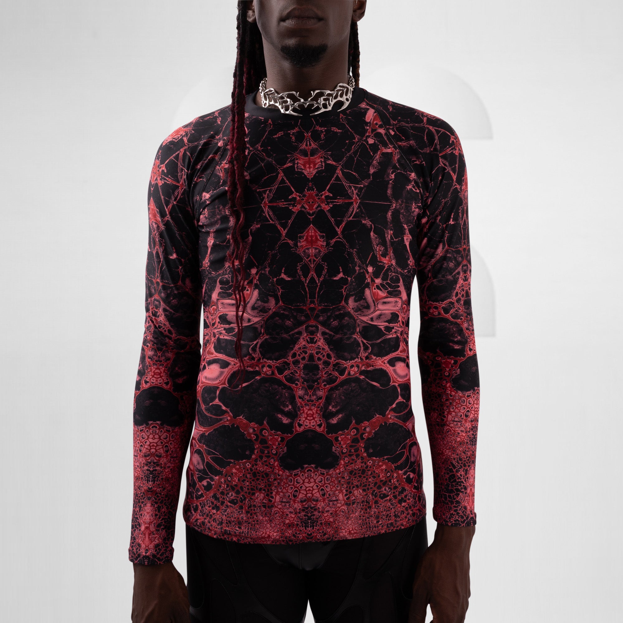 Person wearing a red and black patterned long-sleeve shirt on a white background