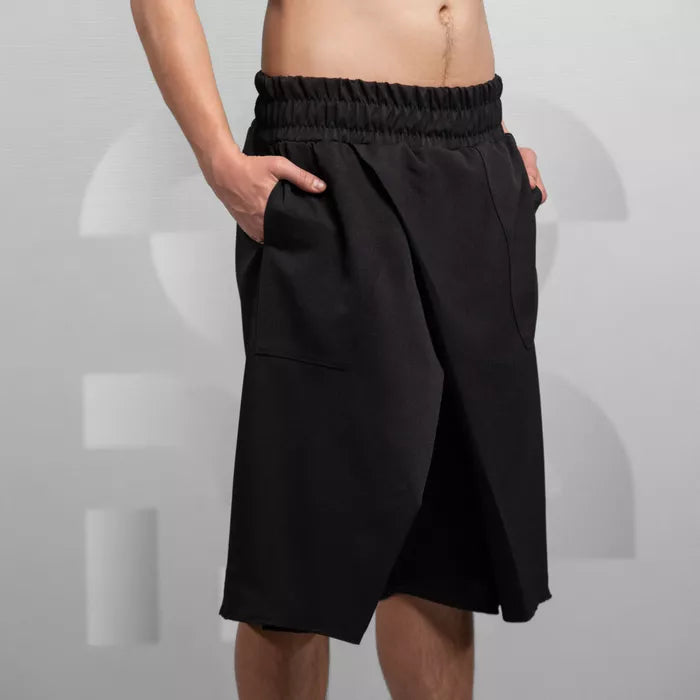 The image features a pair of avant-garde black shorts with a unique, sculptural design. These shorts have an elastic waistband for comfort and are characterized by their roomy pockets and a bold, modern cut that blurs the line between fashion and art. Ideal for making a statement, they are perfect for stylish urban adventures or contemporary fashion events.